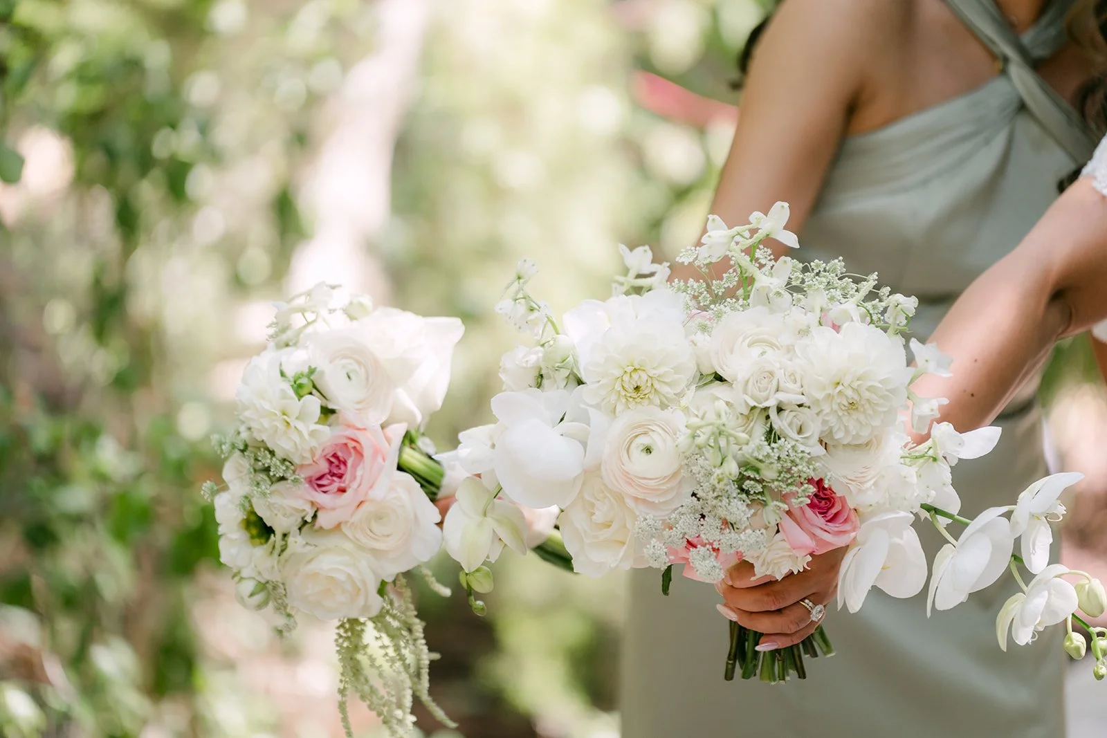 White and blush rose bouquets held by Nicole's bridesmaids.