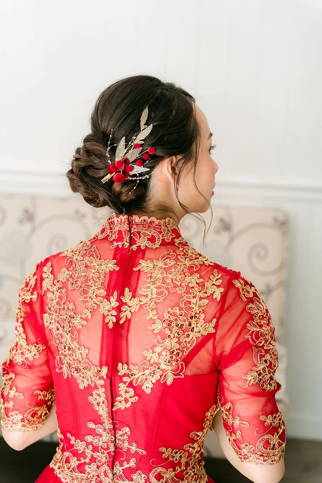 The back of a bride's qun kwa and her gold floral hair pins.
