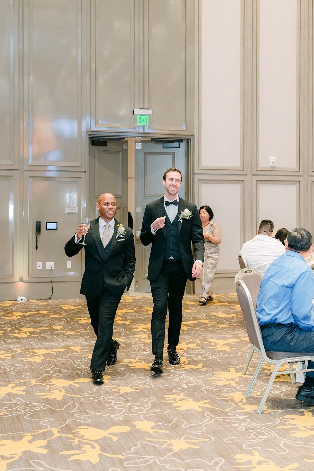 Two groomsmen dancing through the ballroom doors during the grand entrance