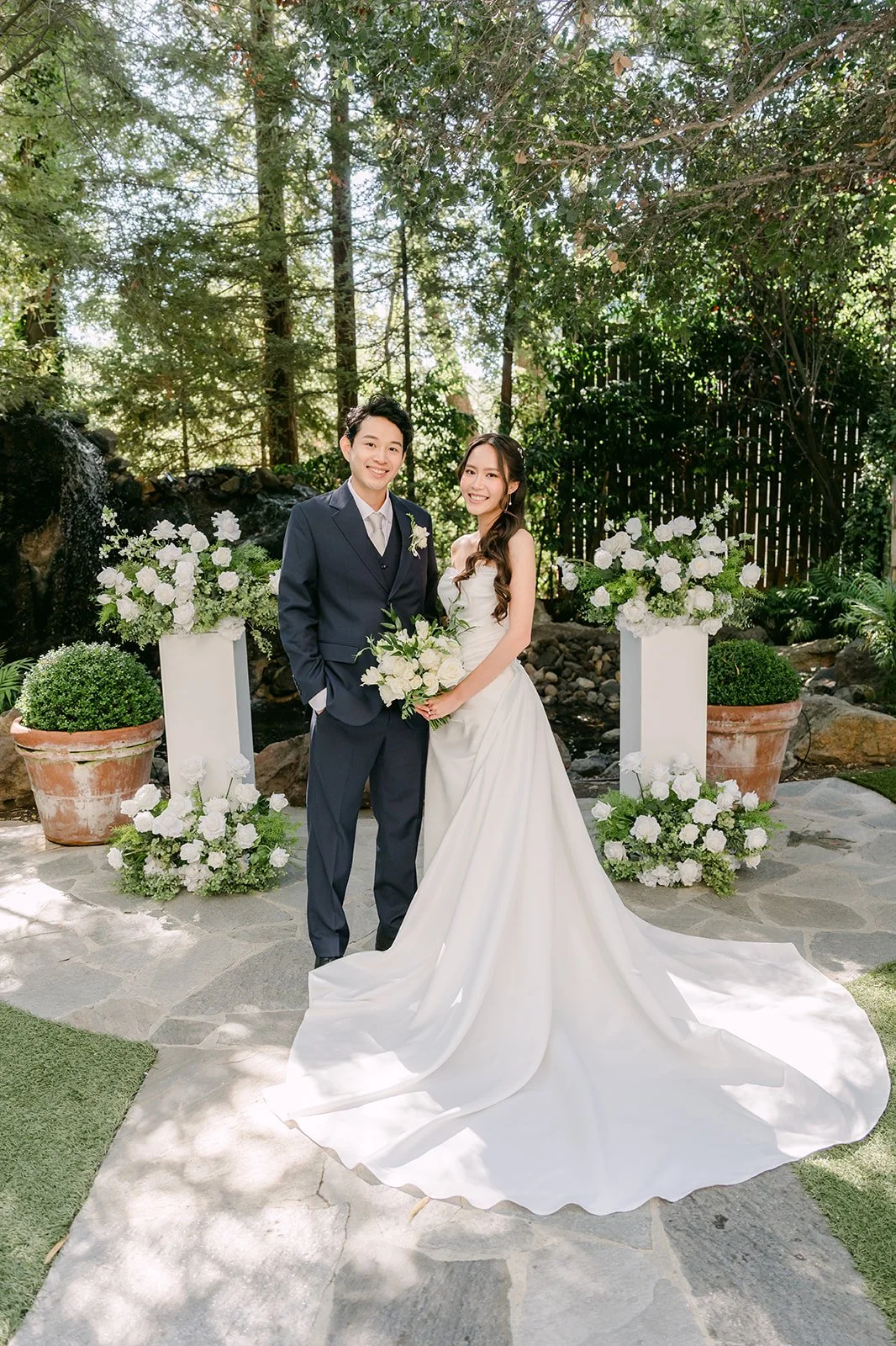 Nhi and Shogo standing in the garden ceremony site after the first look