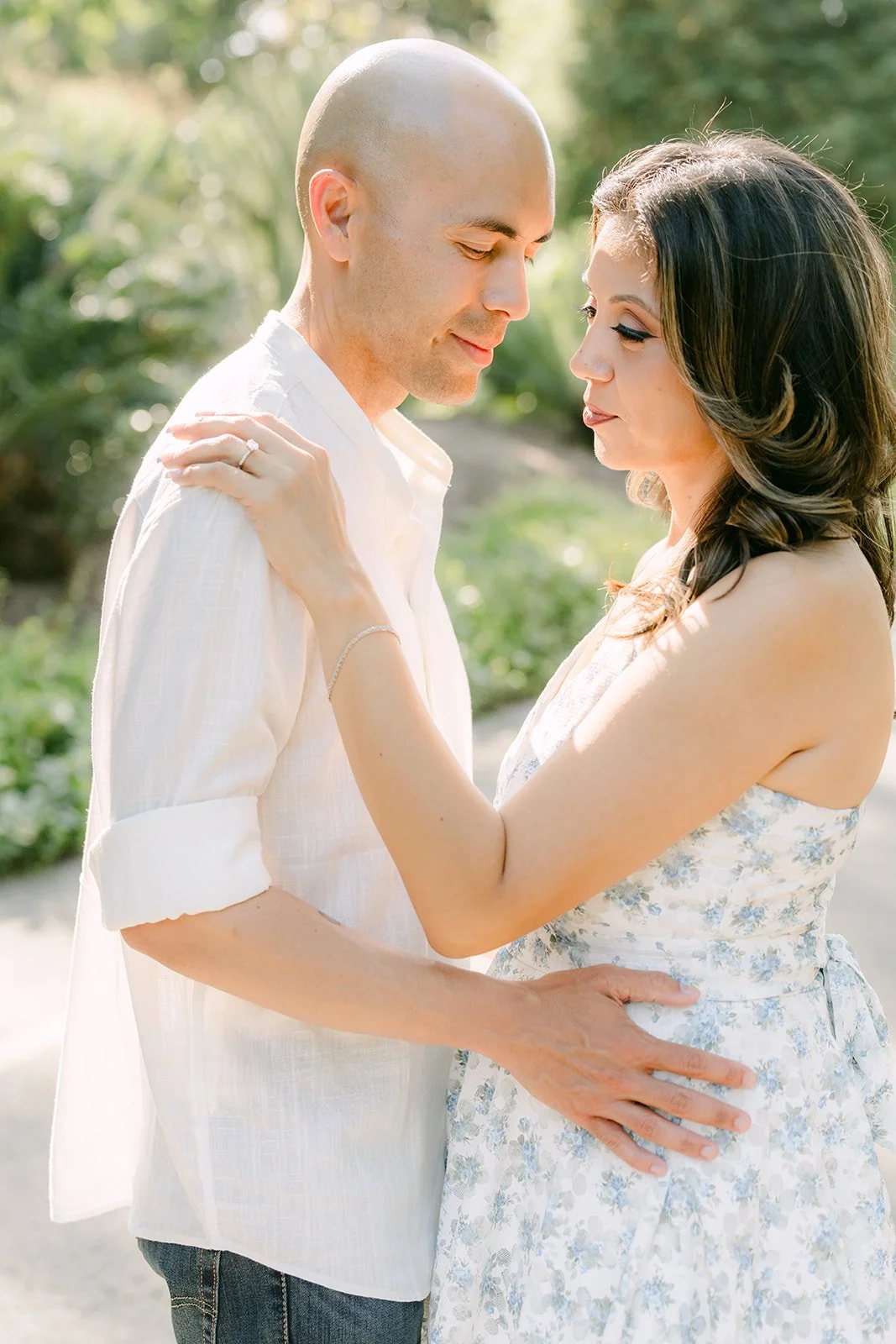 Francesca and Daniel share a quiet embrace among the greenery.
