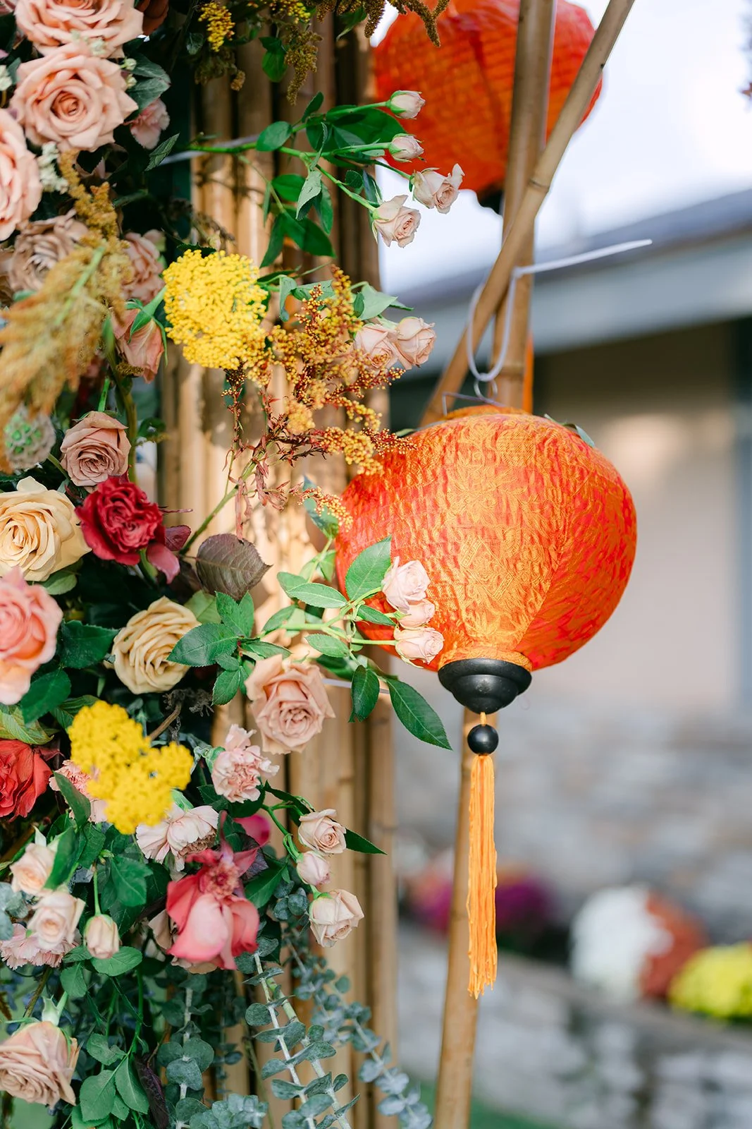 A red lantern hanging among autumn florals outside the family home.