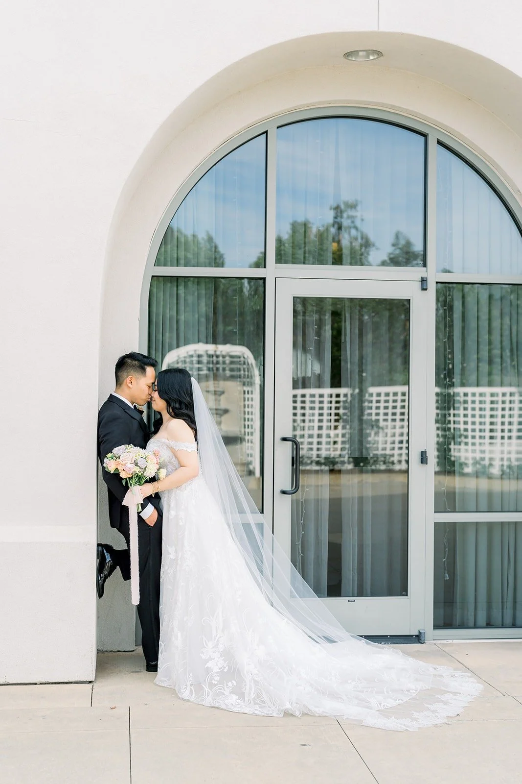Francesca and Ralph by a tall arched doorway with her veil trailing