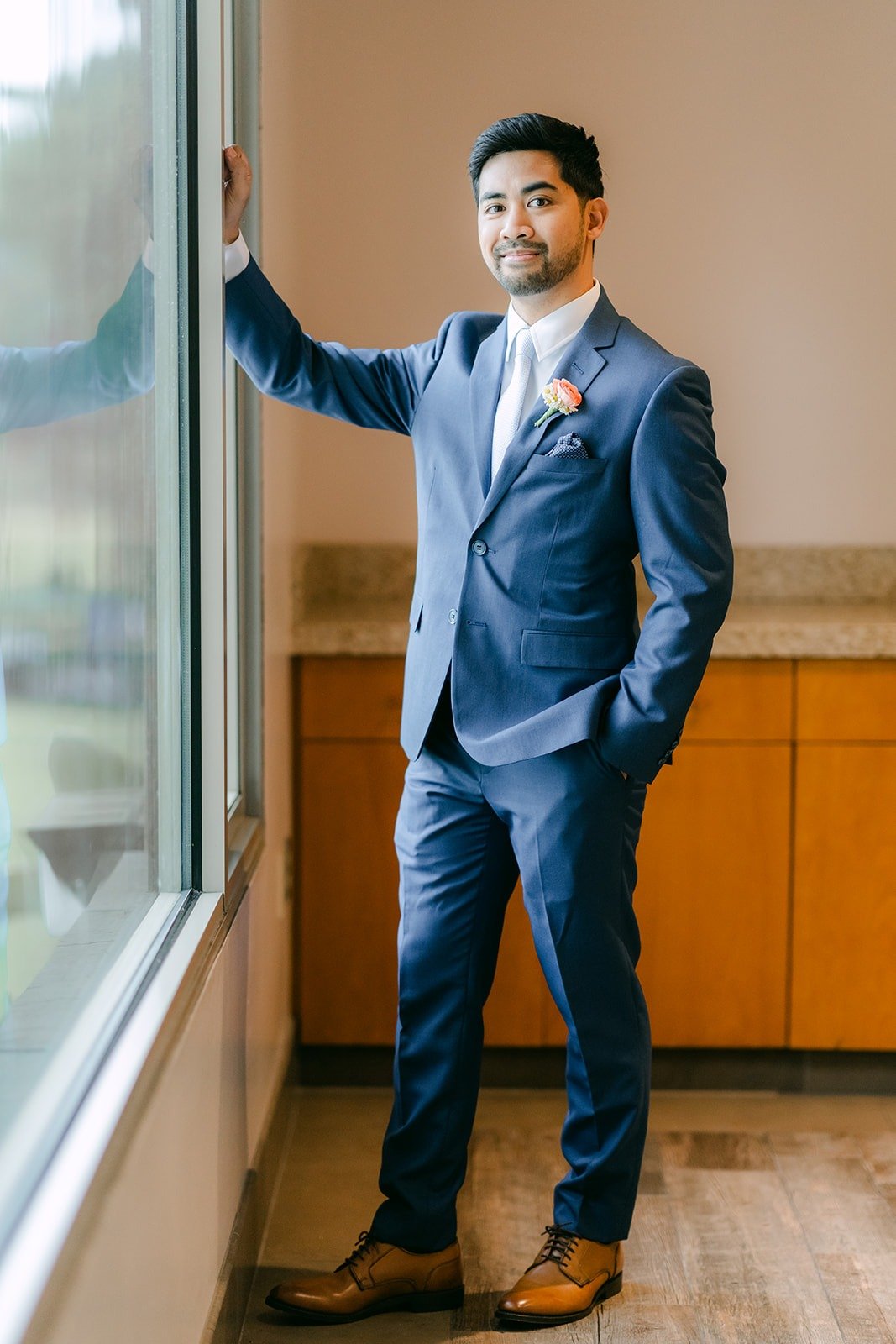 Mark in his blue suit standing by a tall window inside the venue