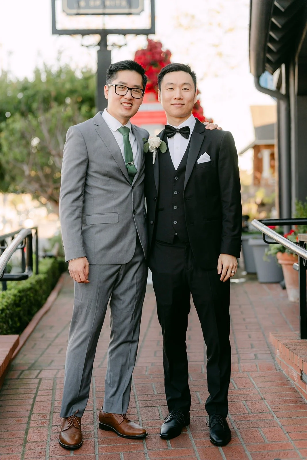Jason and a groomsman posing on the brick walkway
