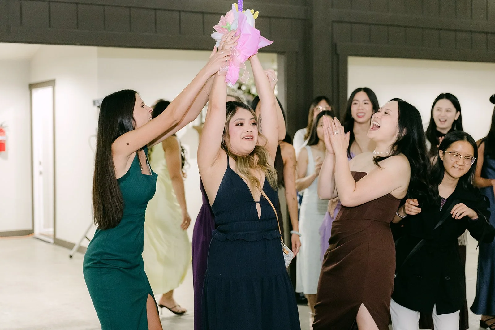 Guests reaching for the light-up bouquet during the bouquet toss.