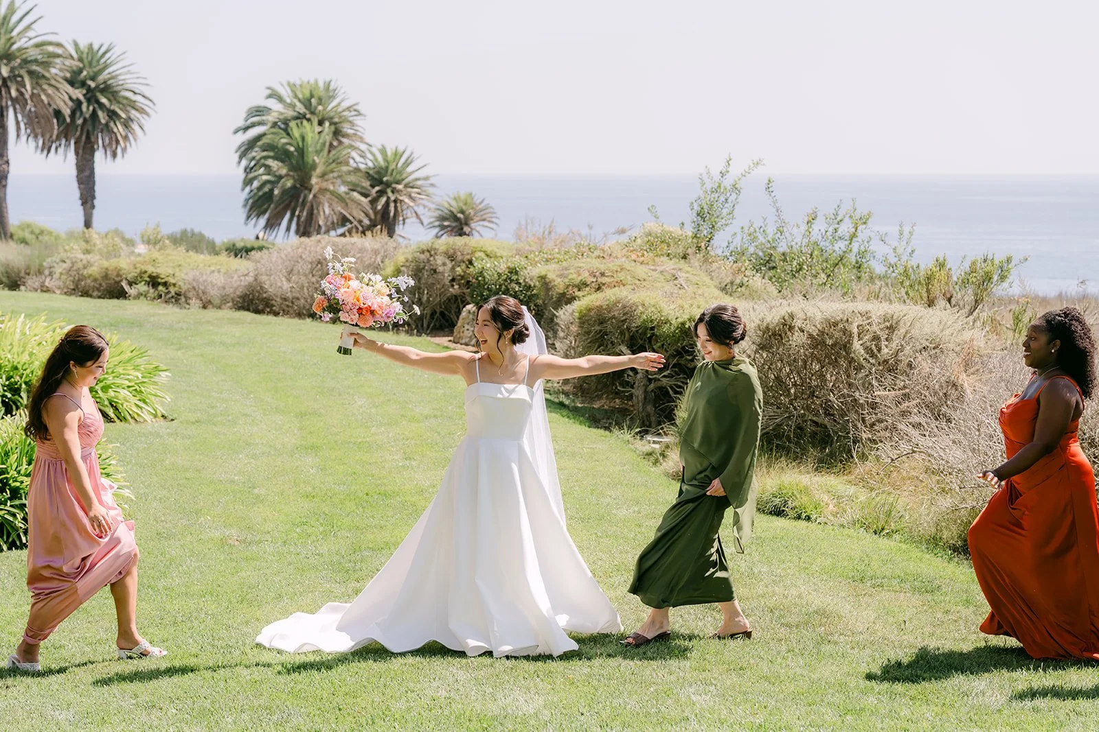 Saya revealing her gown to her bridesmaids on the lawn