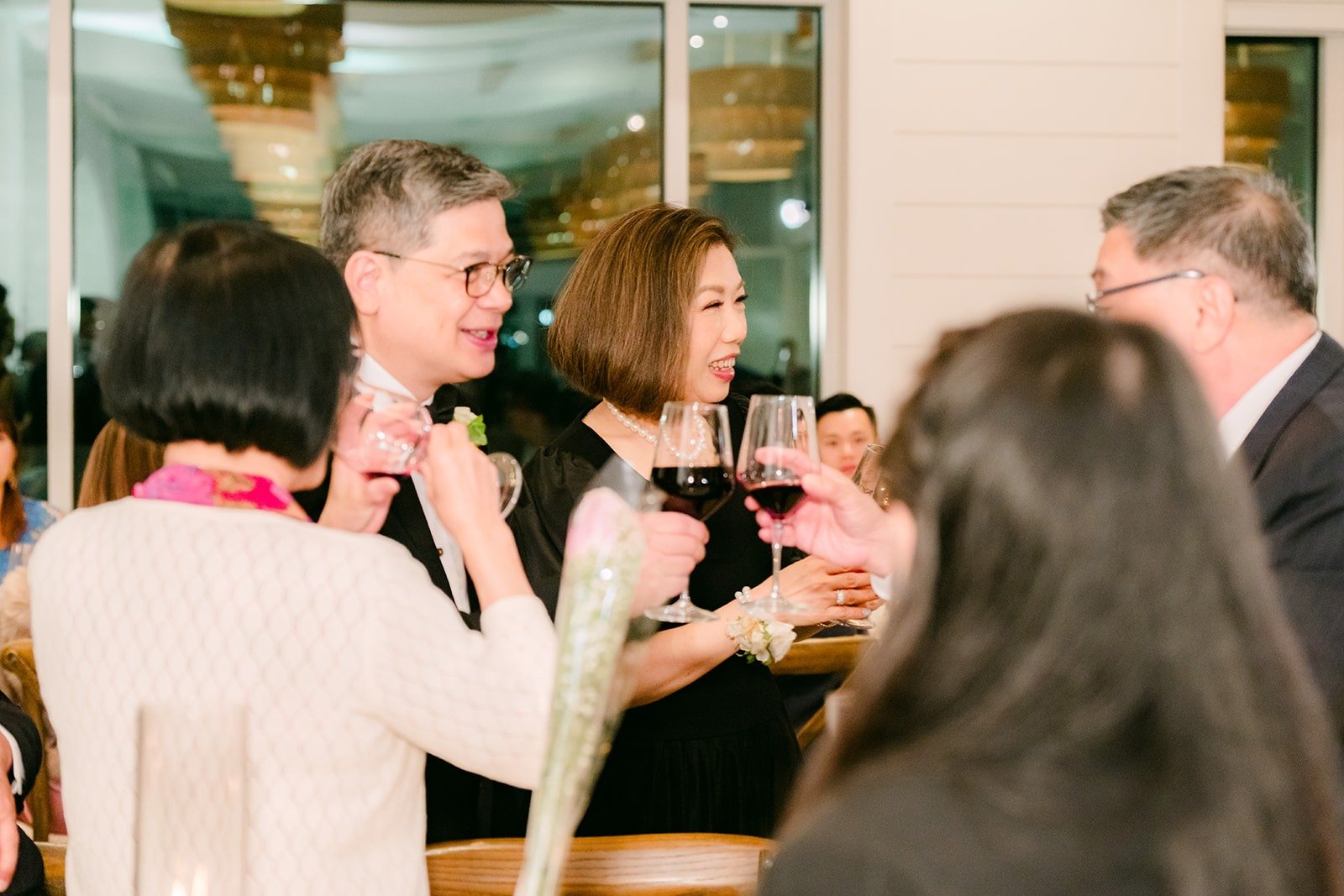 Guests raising their glasses during the table visits, photographed by One and Only Production