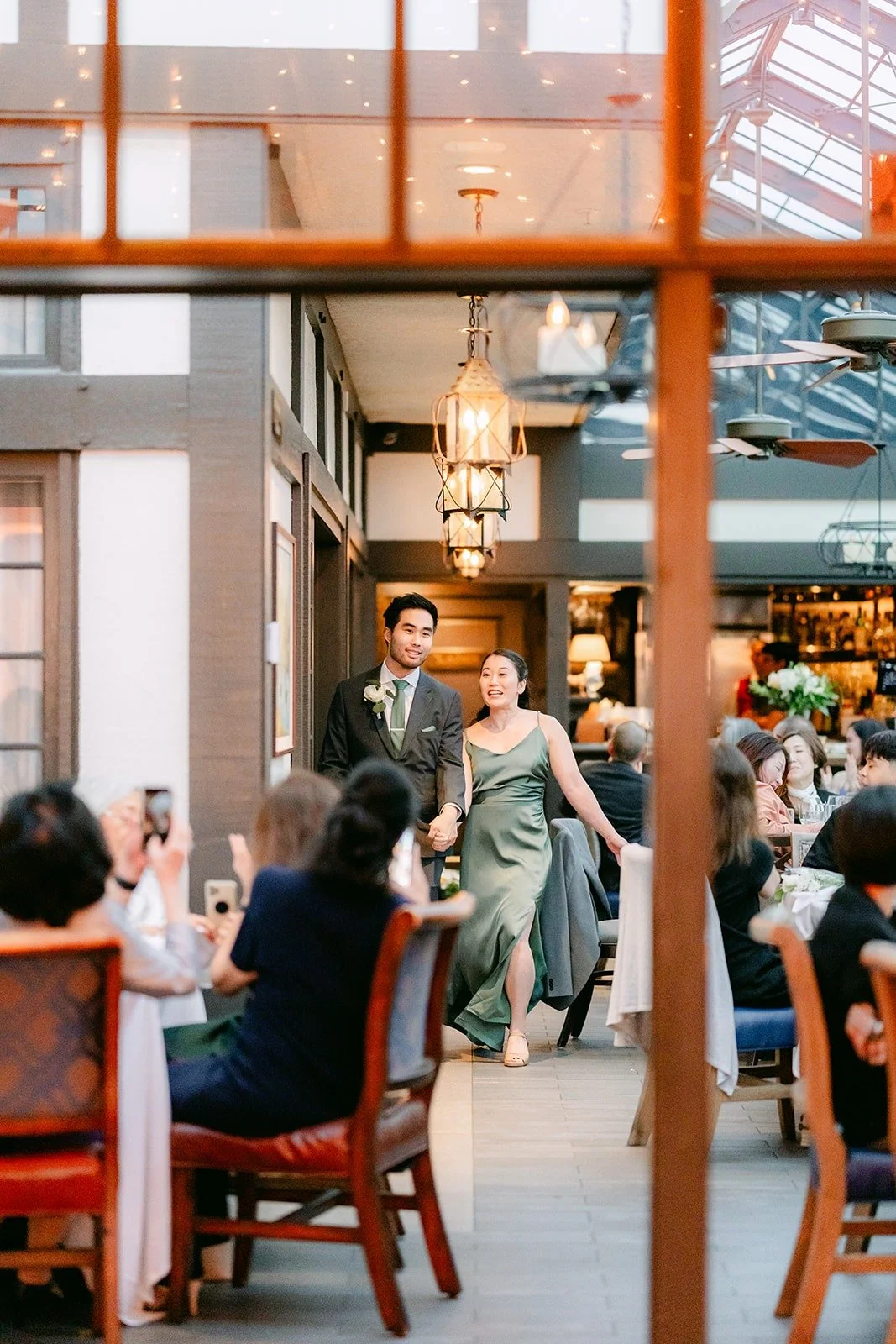 Guests clapping as the wedding party enters the dining room