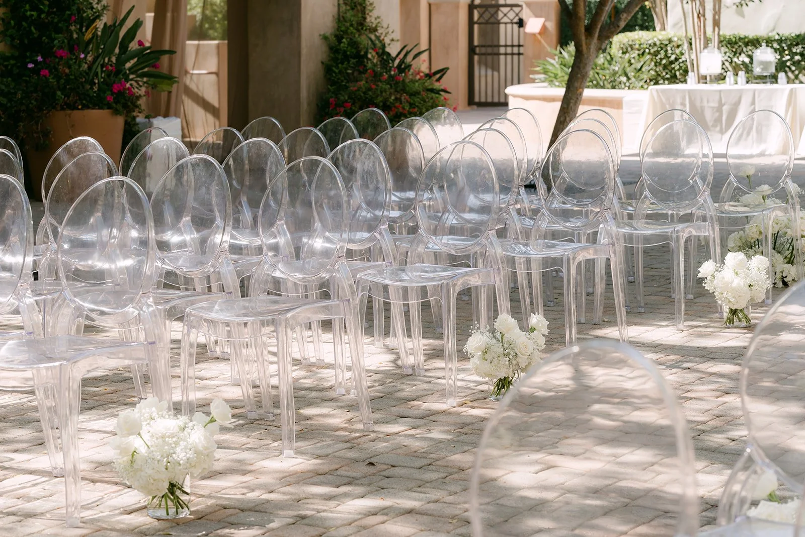 Rows of ghost chairs on the stone pavers before guests arrive