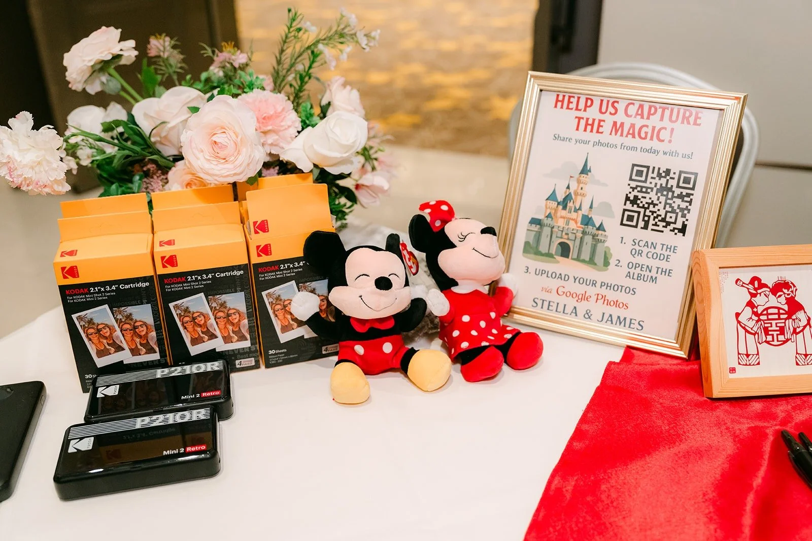 Mickey and Minnie plush toys on the welcome table beside a sign and small favors