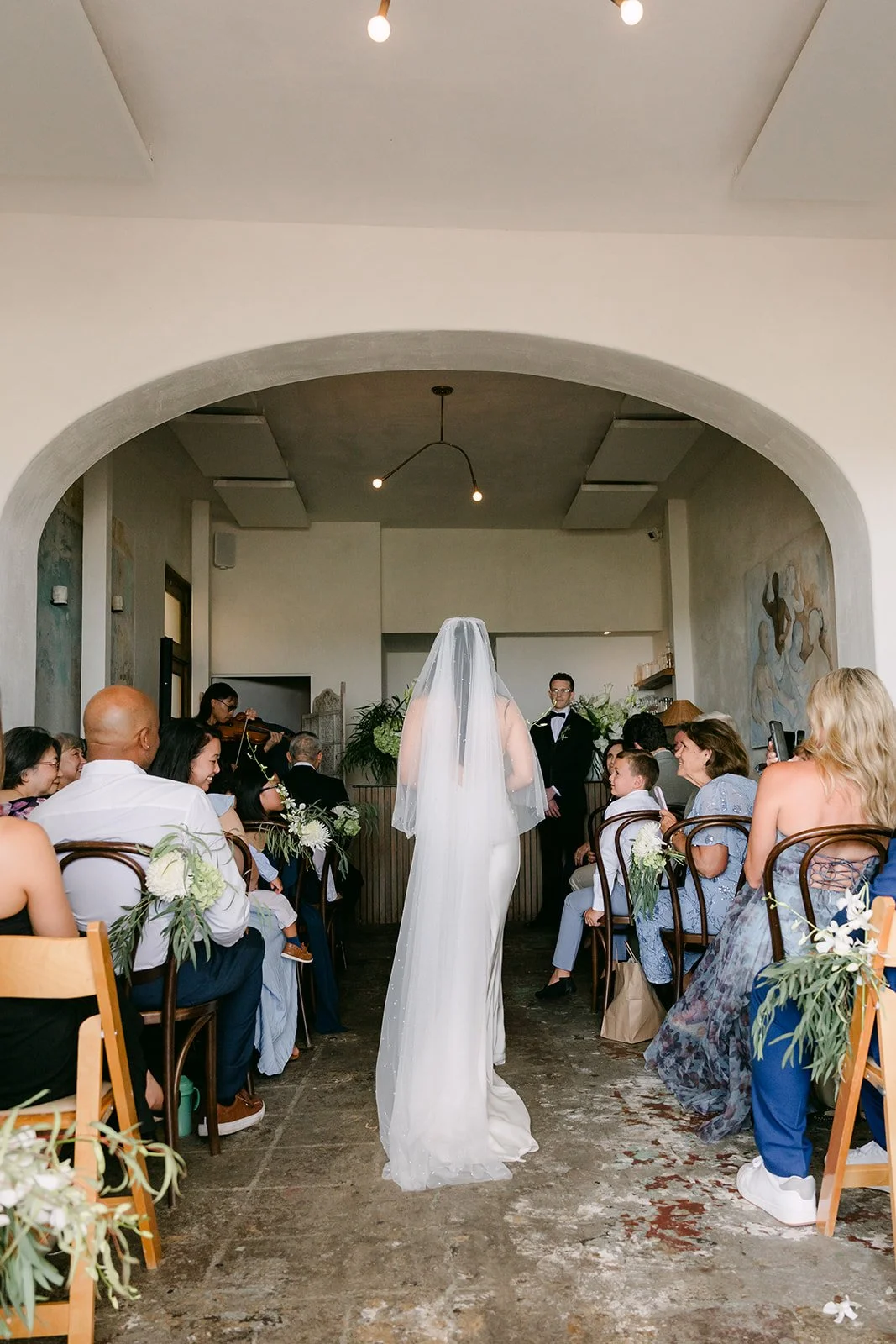 Justine walking down the aisle in her long veil