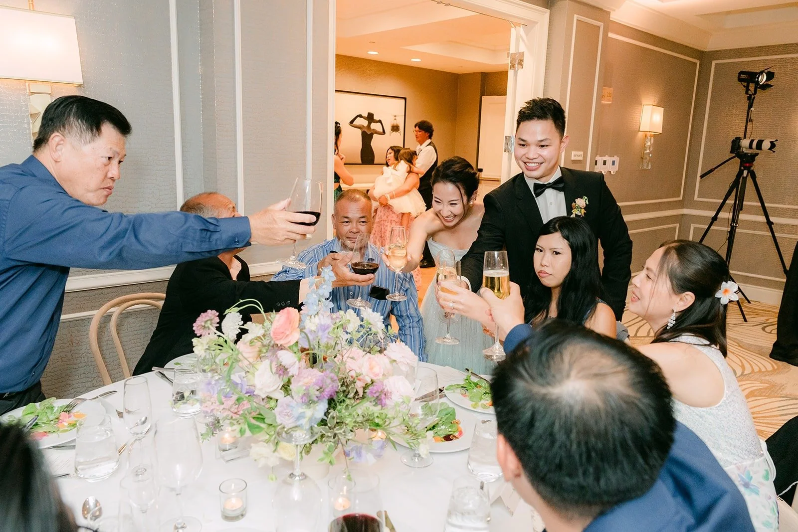 Kylie and Mario raising a glass with guests during table greetings