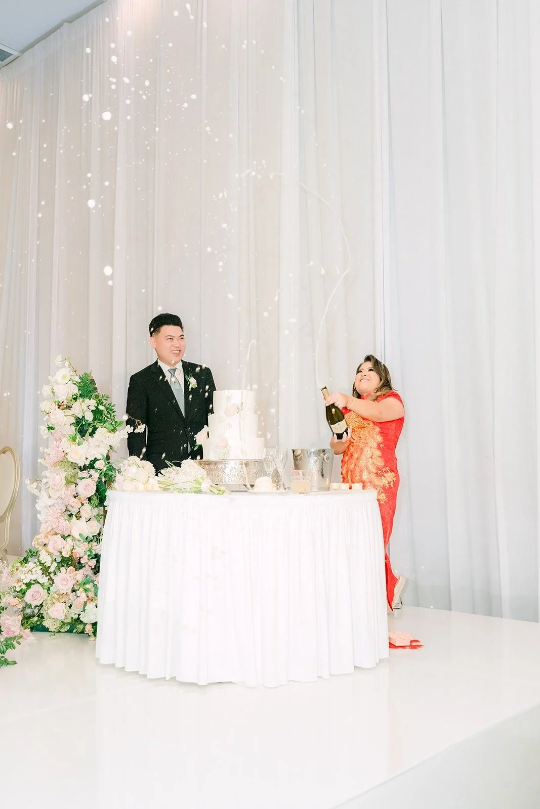 Candice and Vincent laughing at the cake table