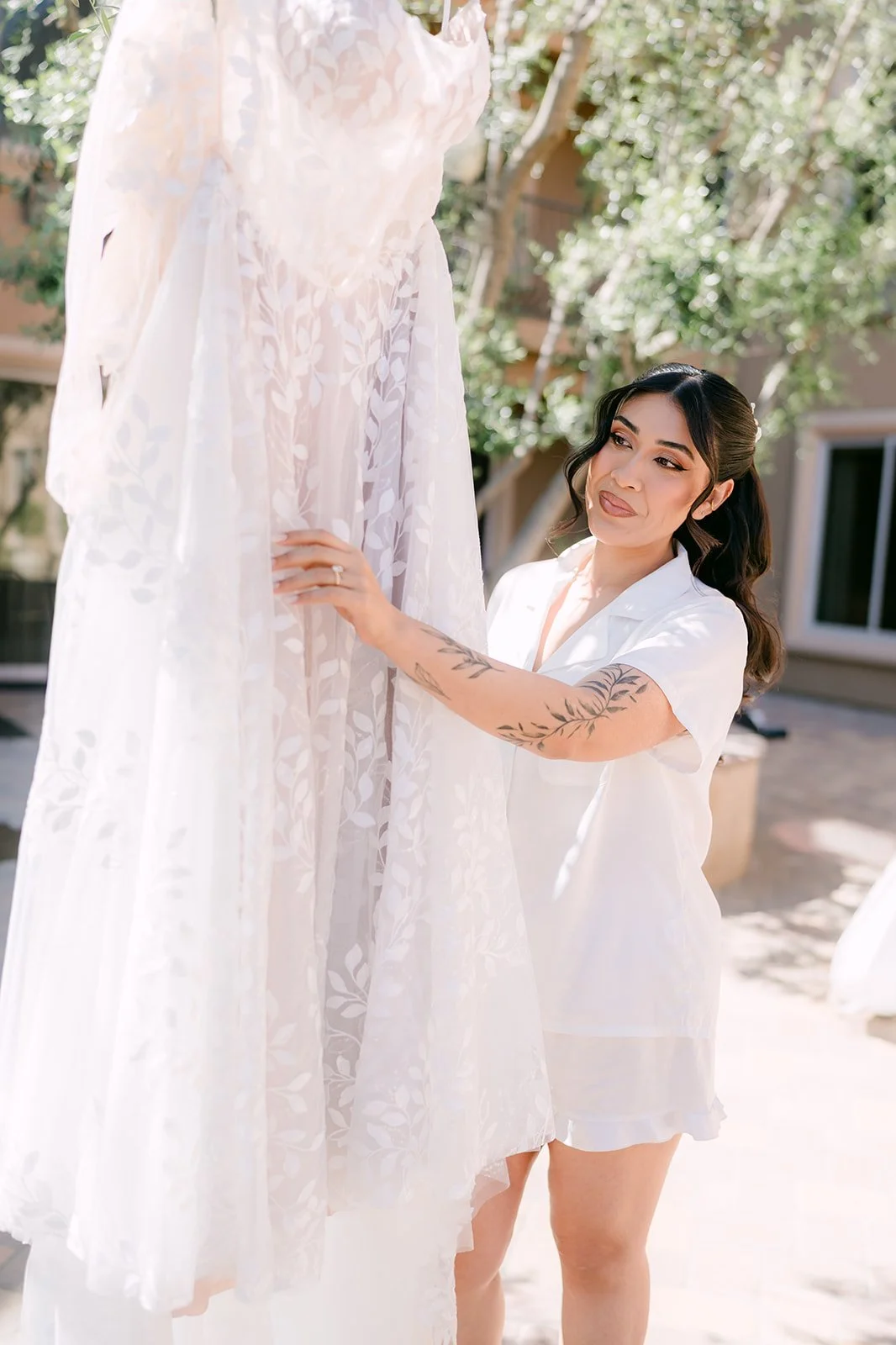 Fernanda in a white robe reaching for her gown.