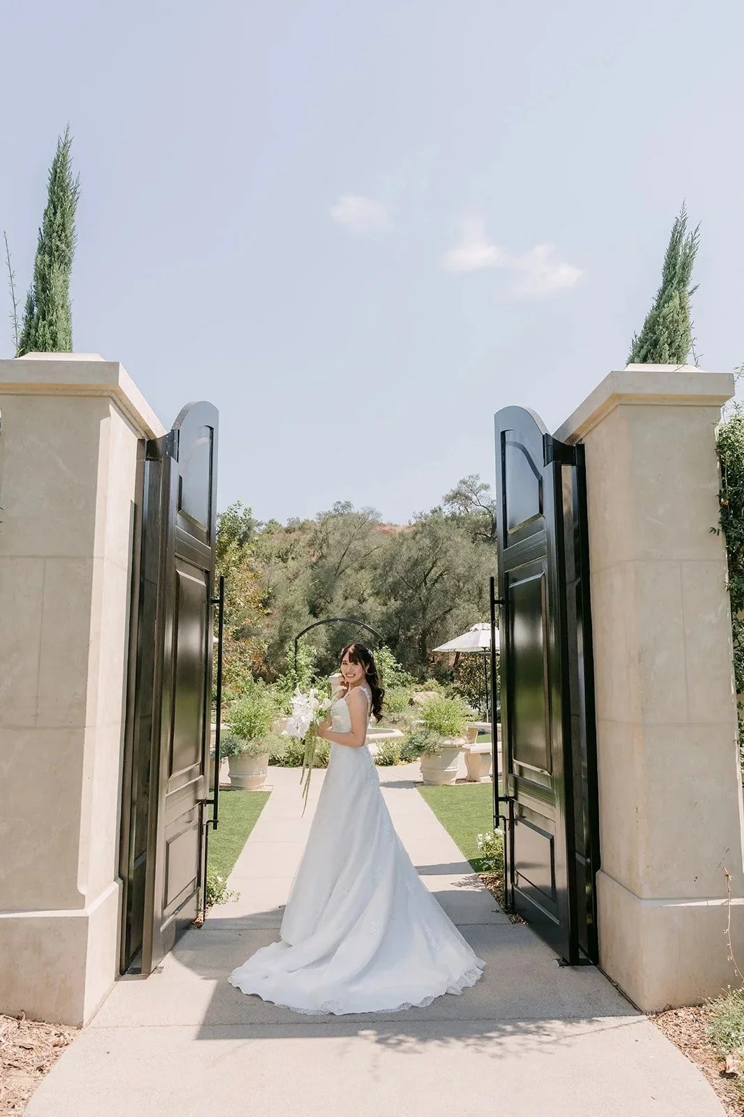 Marina walking toward Tyler through the open garden gates