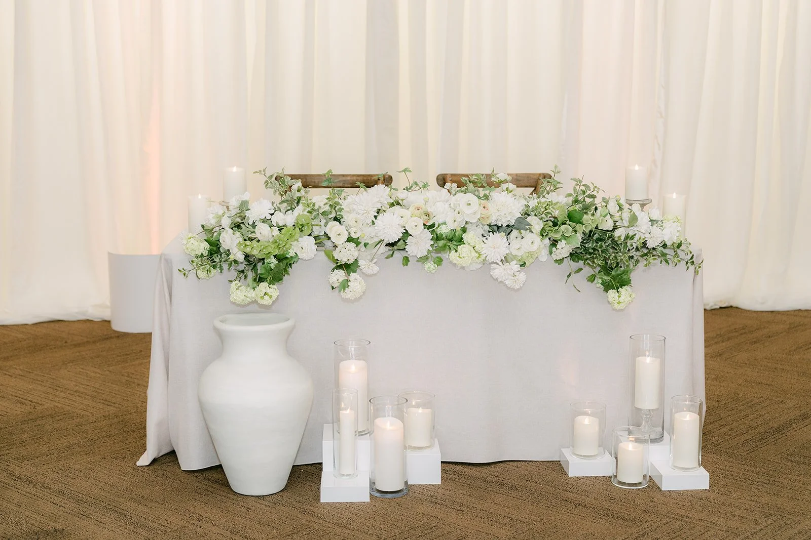The sweetheart table with white florals and candles.