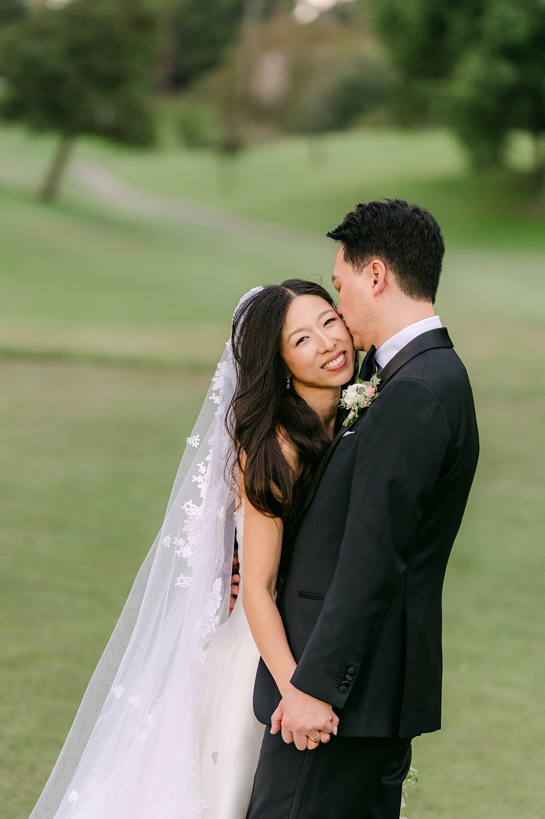 Kristine and William laughing together on the green