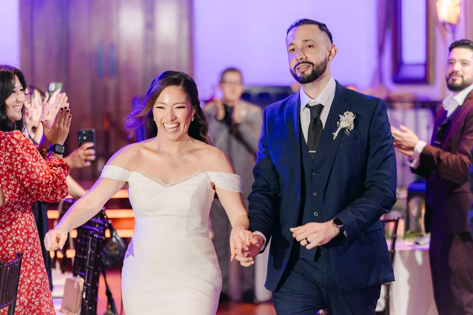 Mariana and Danny walking in hand in hand to applause