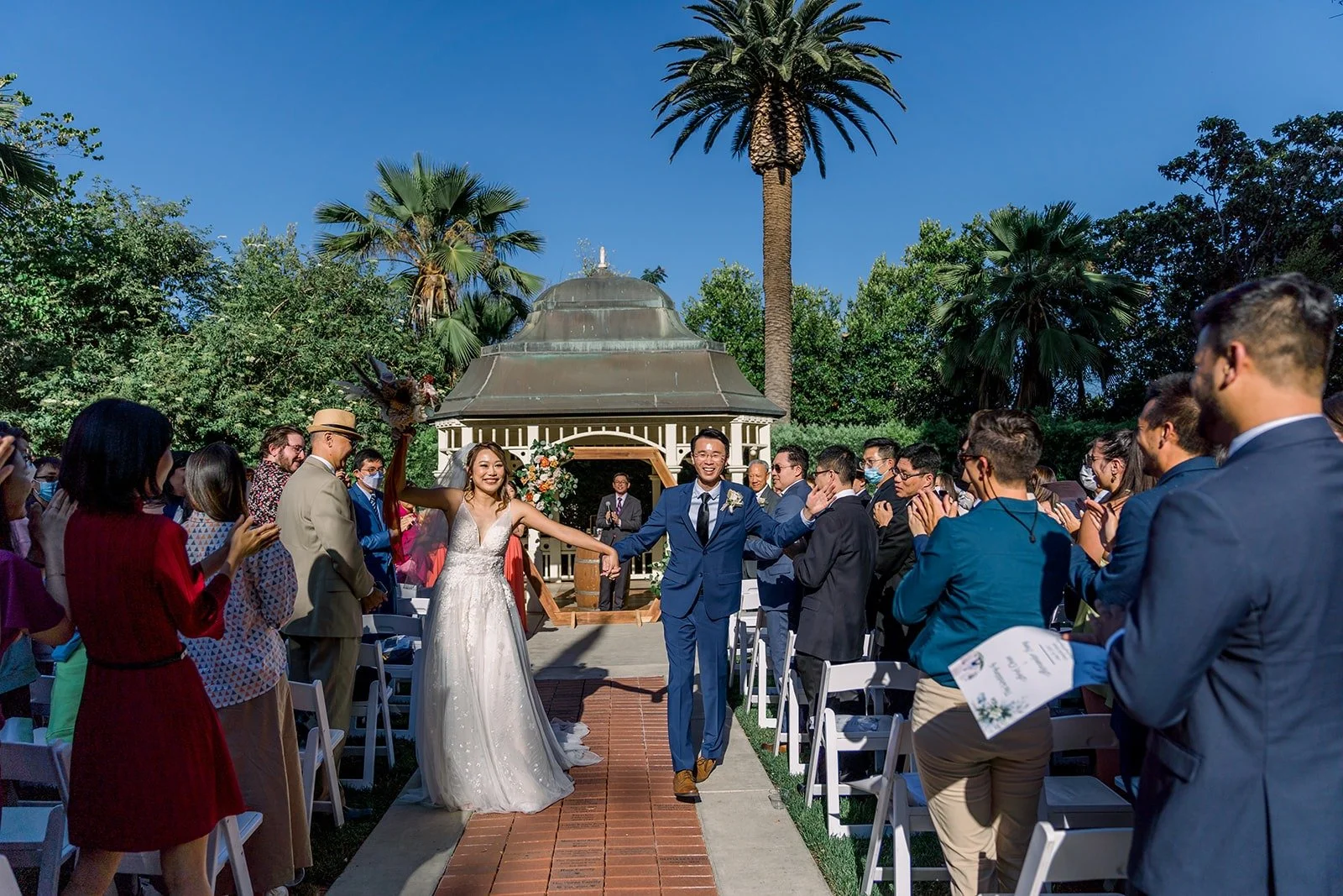 Ariel and Alex walking back up the aisle as newlyweds, photographed by One and Only Production
