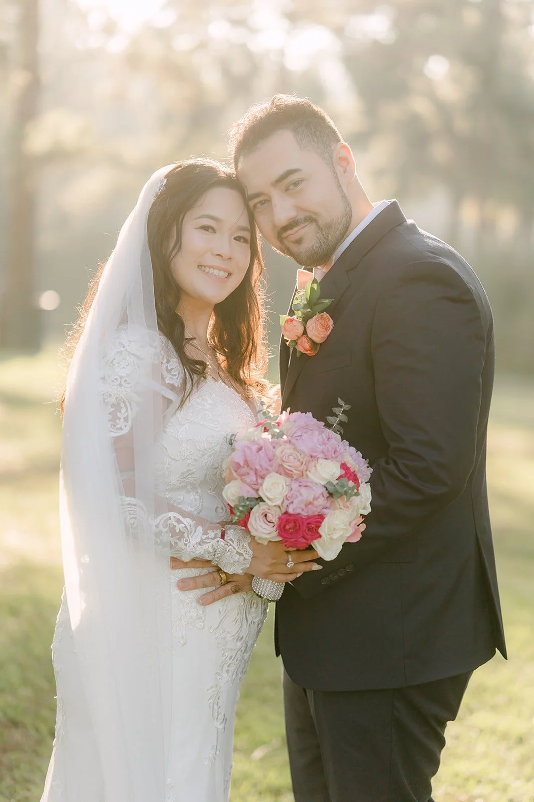 Amy and James laughing together, her pink bouquet between them