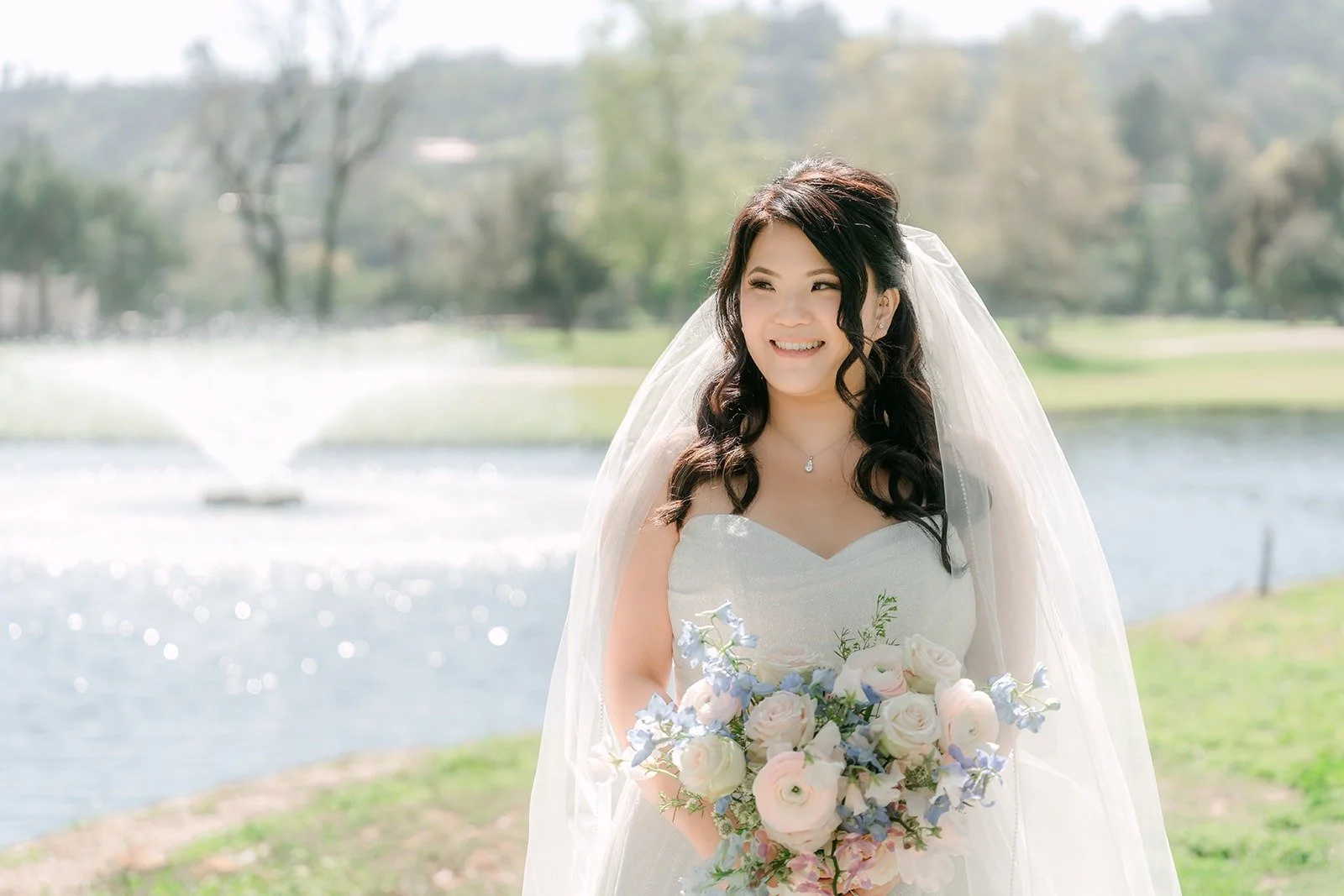 Florence with her veil in front of the fountain at Brookside Golf Club