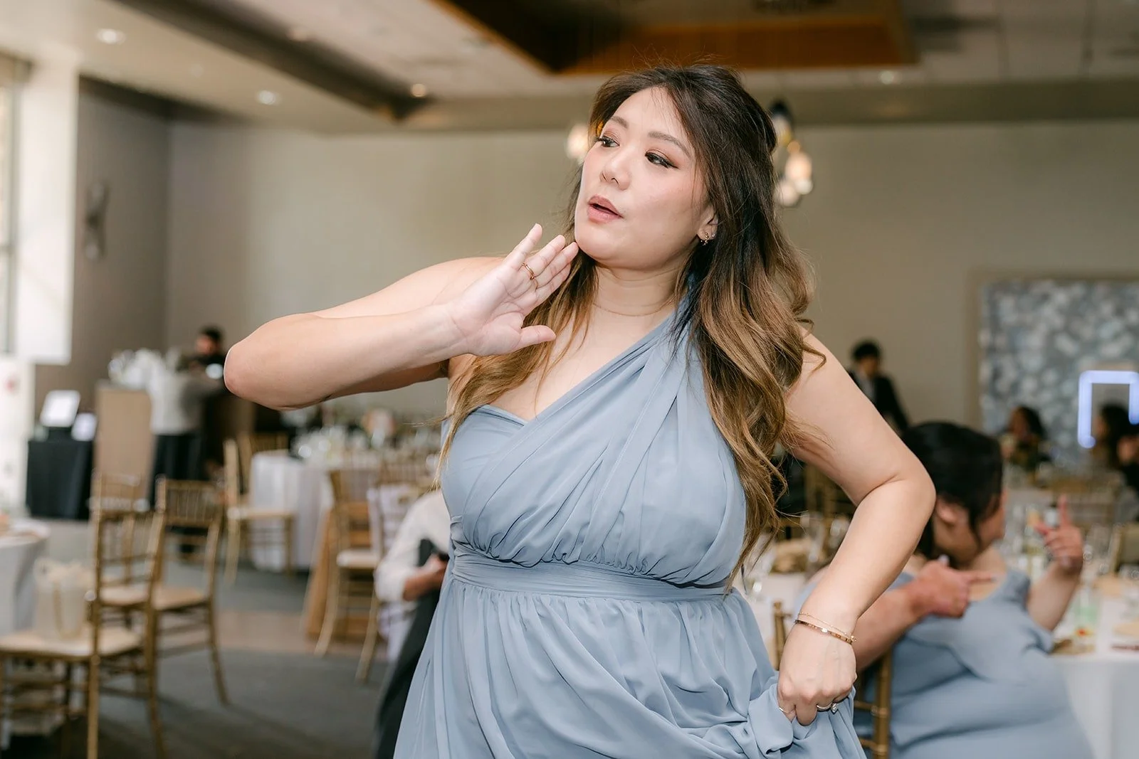 A bridesmaid blowing a kiss to the camera on the dance floor