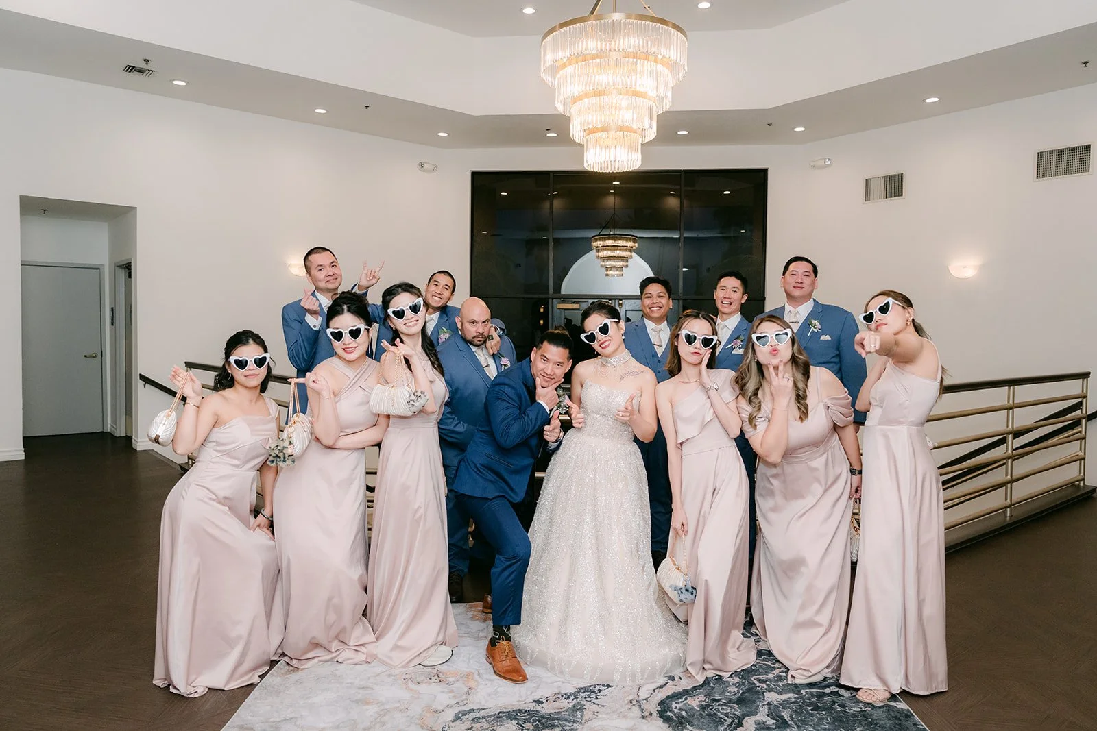 The bridesmaids and groomsmen posing in sunglasses during the grand entrance.