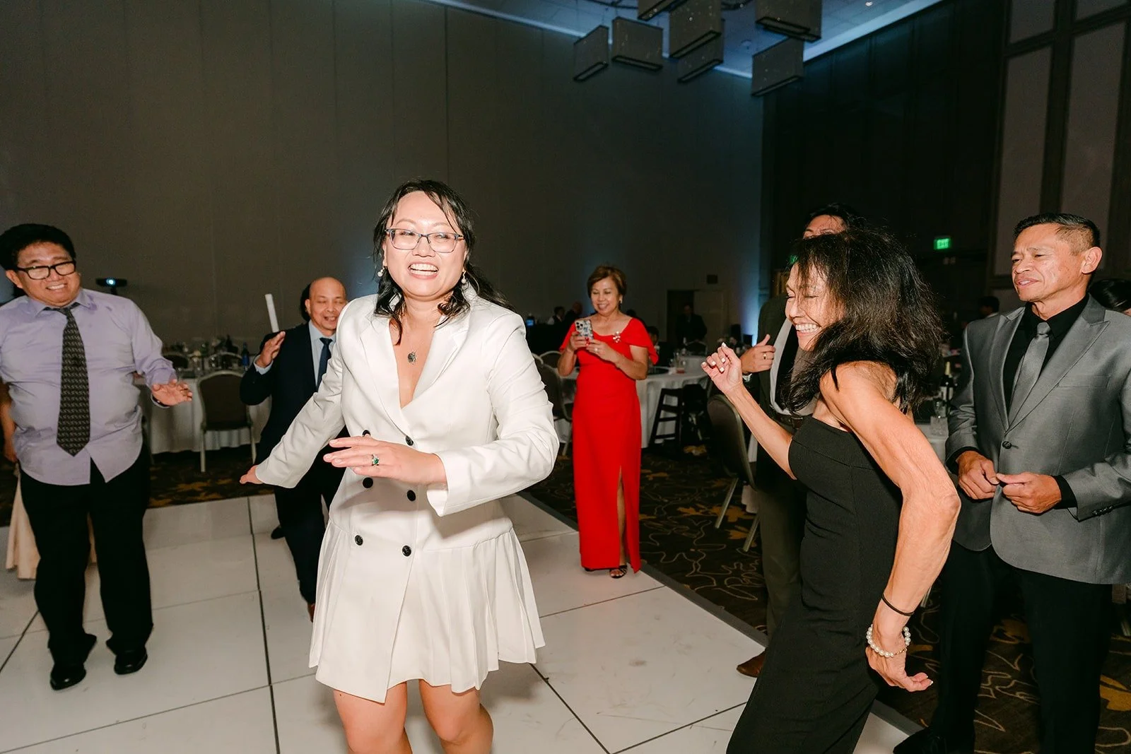 Stella dancing in her white suit jacket on the dance floor