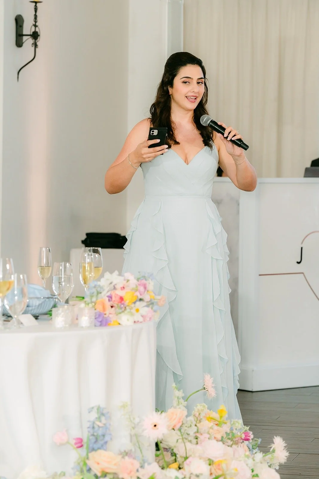 A bridesmaid giving a toast with the microphone