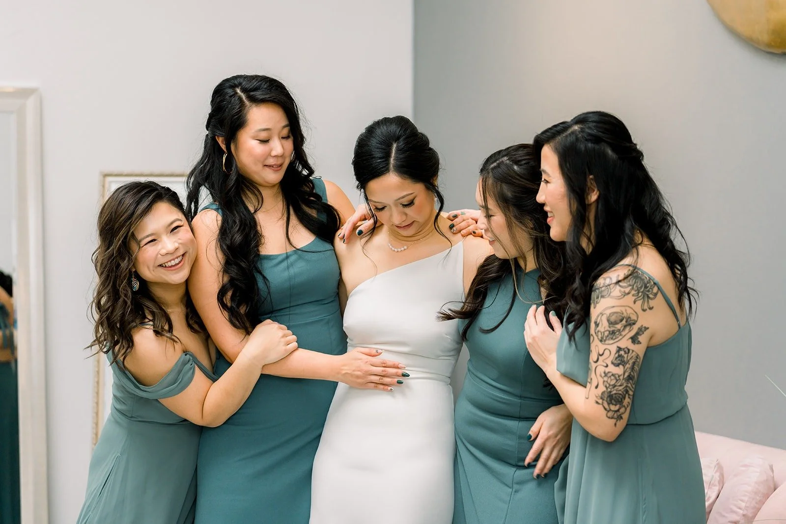 Cindy laughing with her bridesmaids in sage green dresses