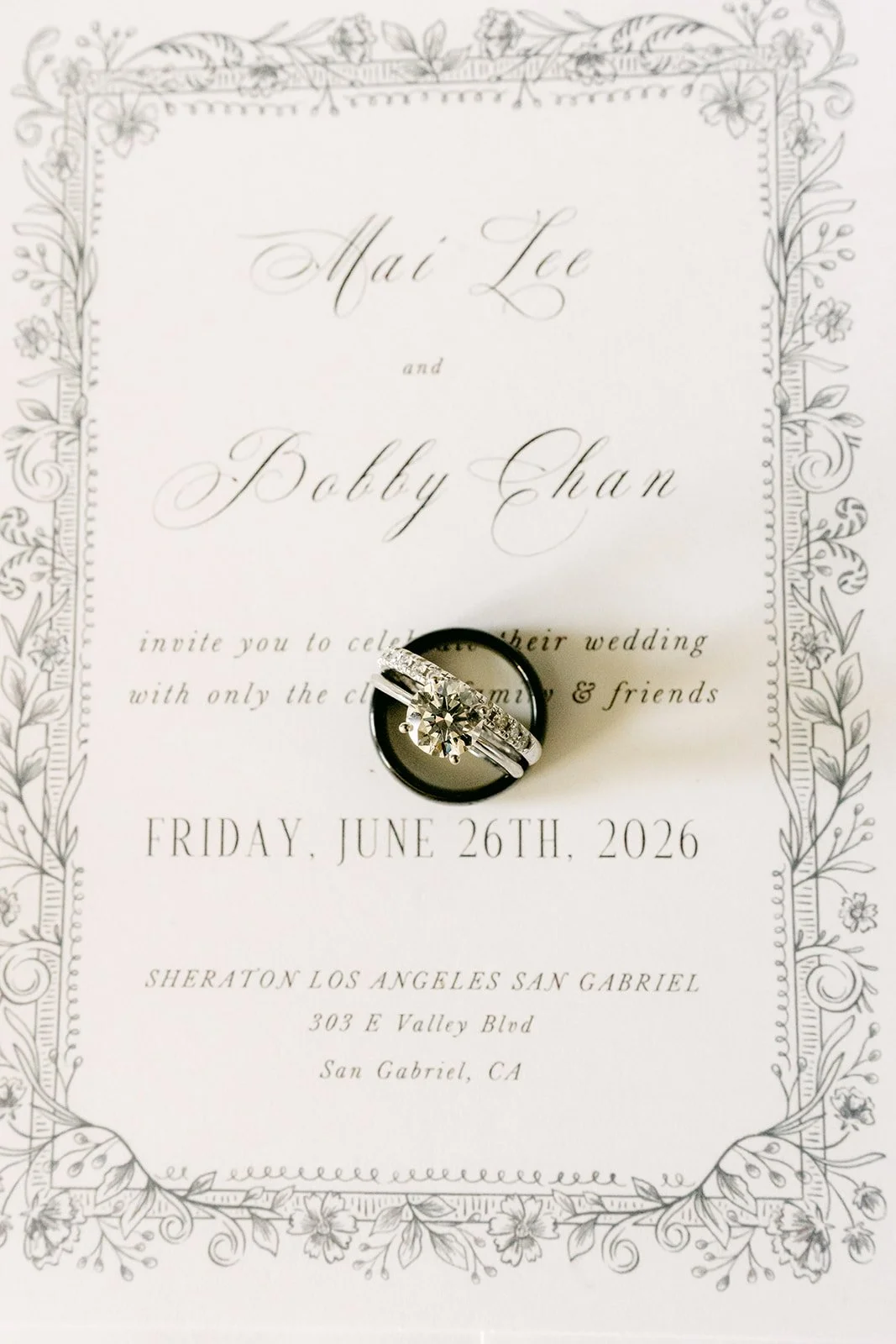 Mai and Bobby's invitation with their wedding rings.