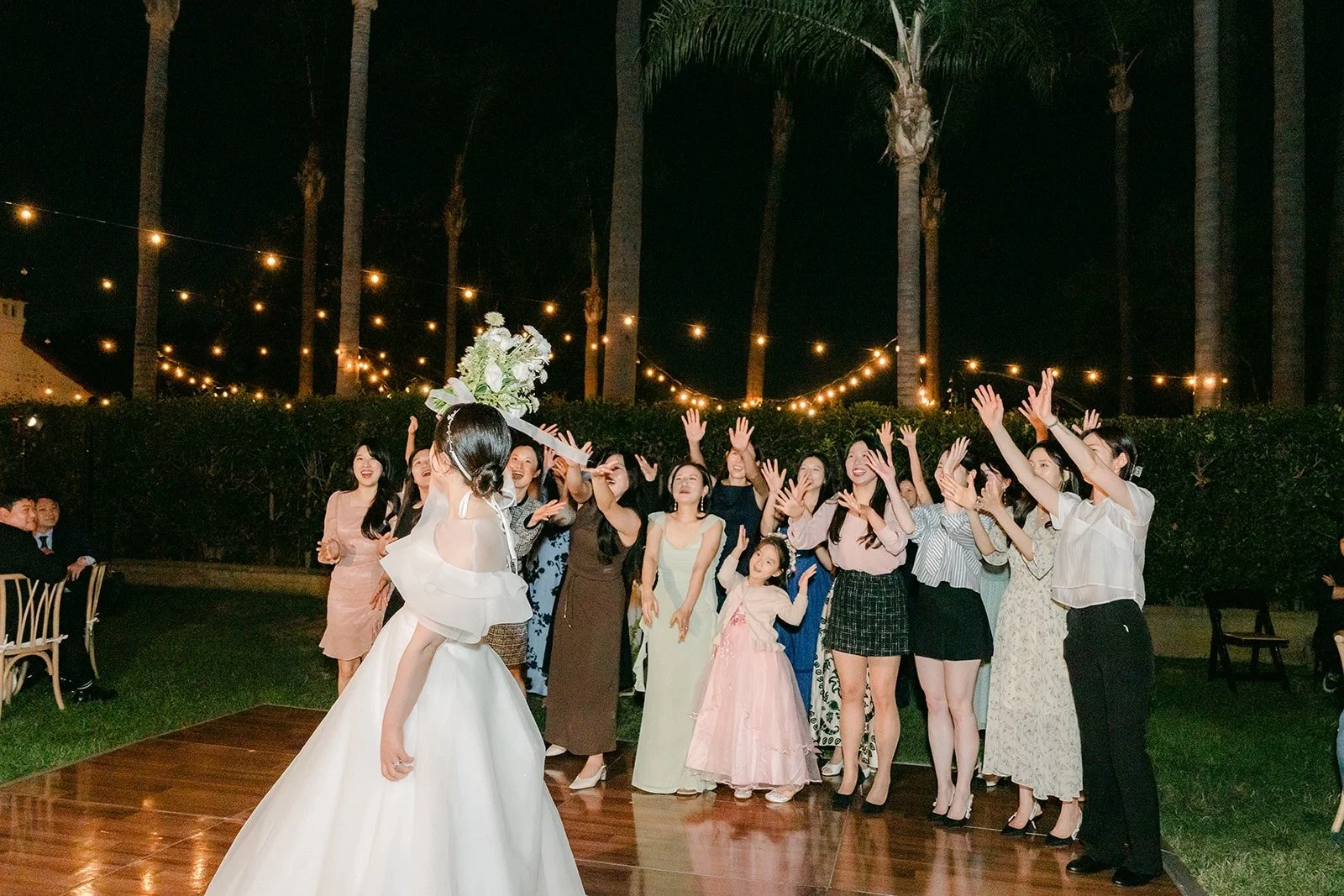 Guests gathered for the bouquet toss at night