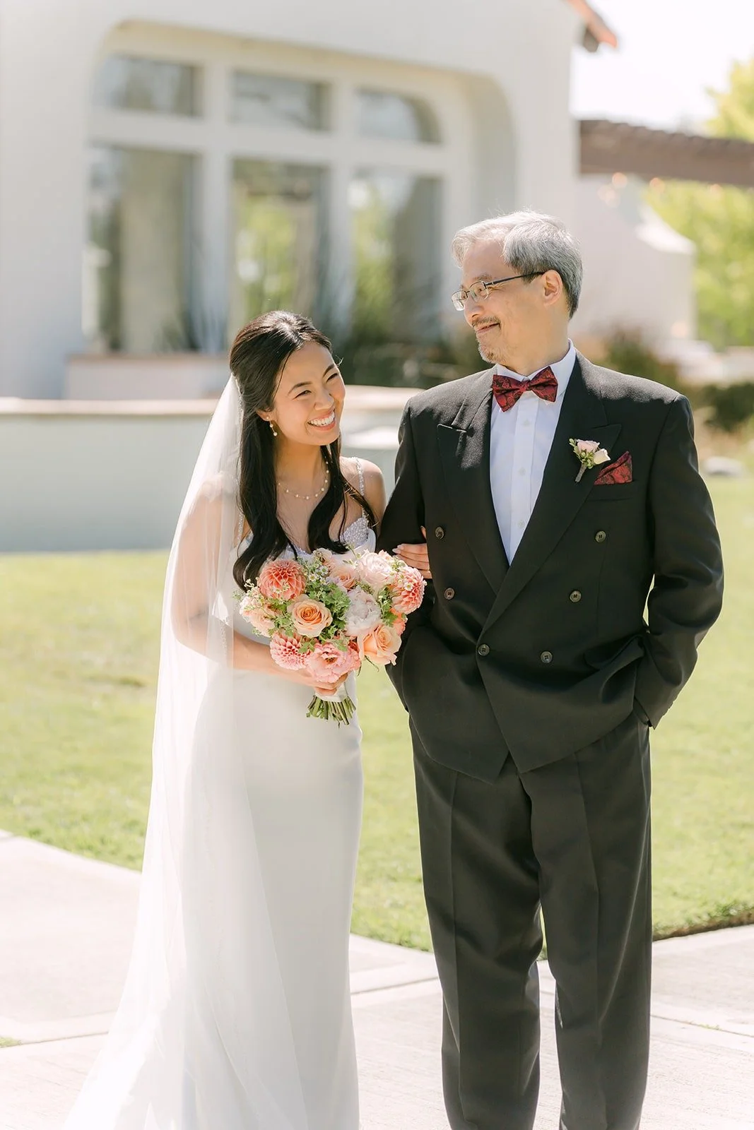 Stephanie and a family member in a black tuxedo and red bow tie smiling together
