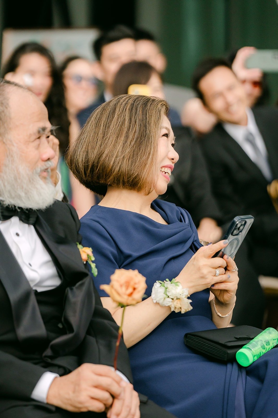 Guests in the front row smiling during the ceremony