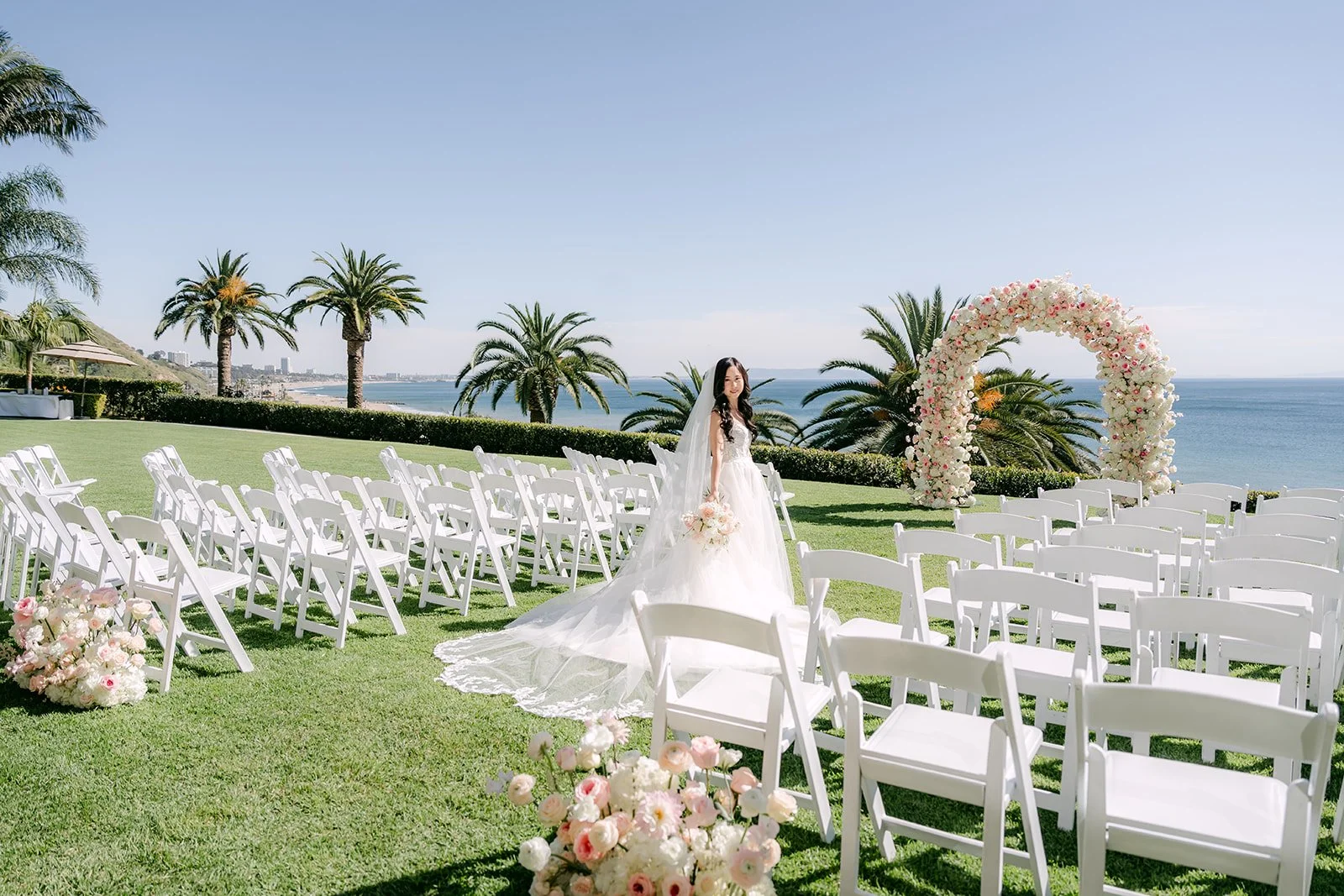 Lawn ceremony setup with a floral arch overlooking the Pacific at Bel-Air Bay Club