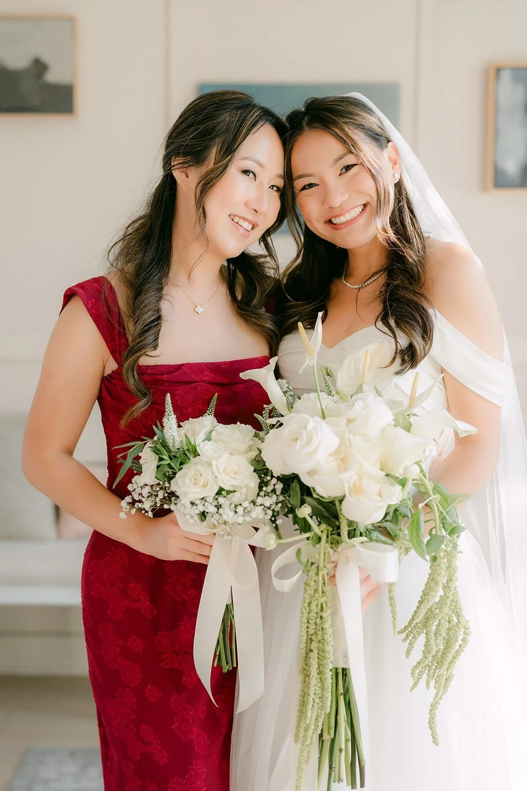 Jadee and a bridesmaid cheek to cheek with their bouquets