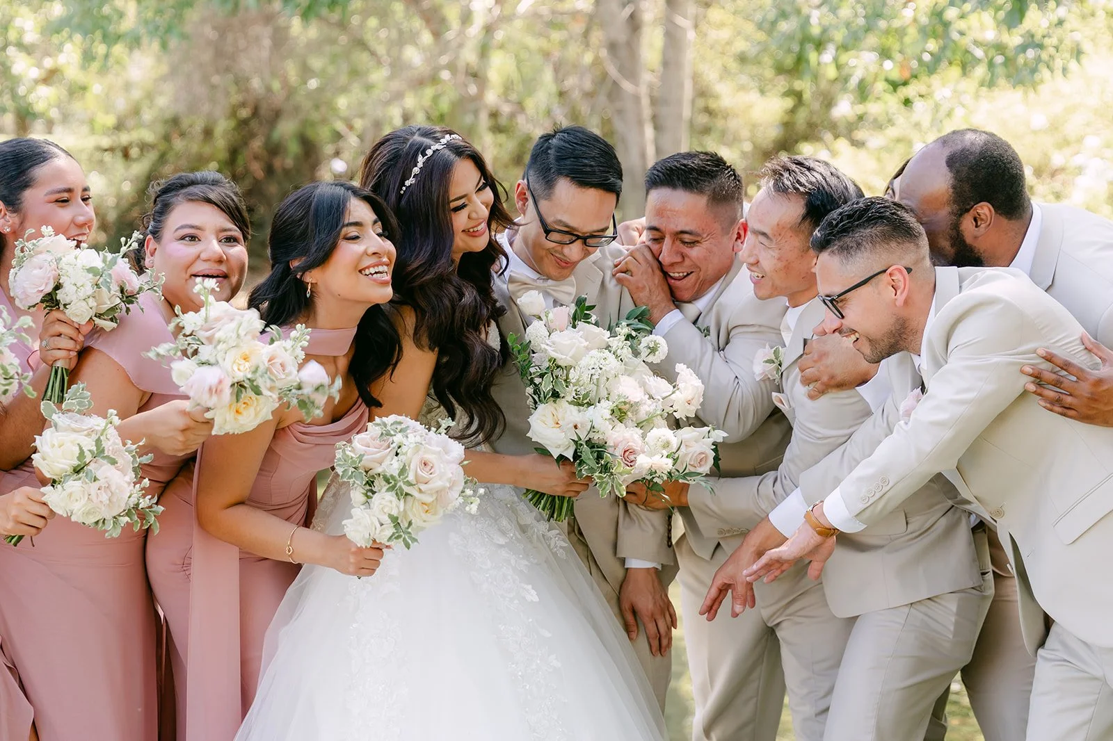 The wedding party crowding around Sandra and Kevin for a group hug.