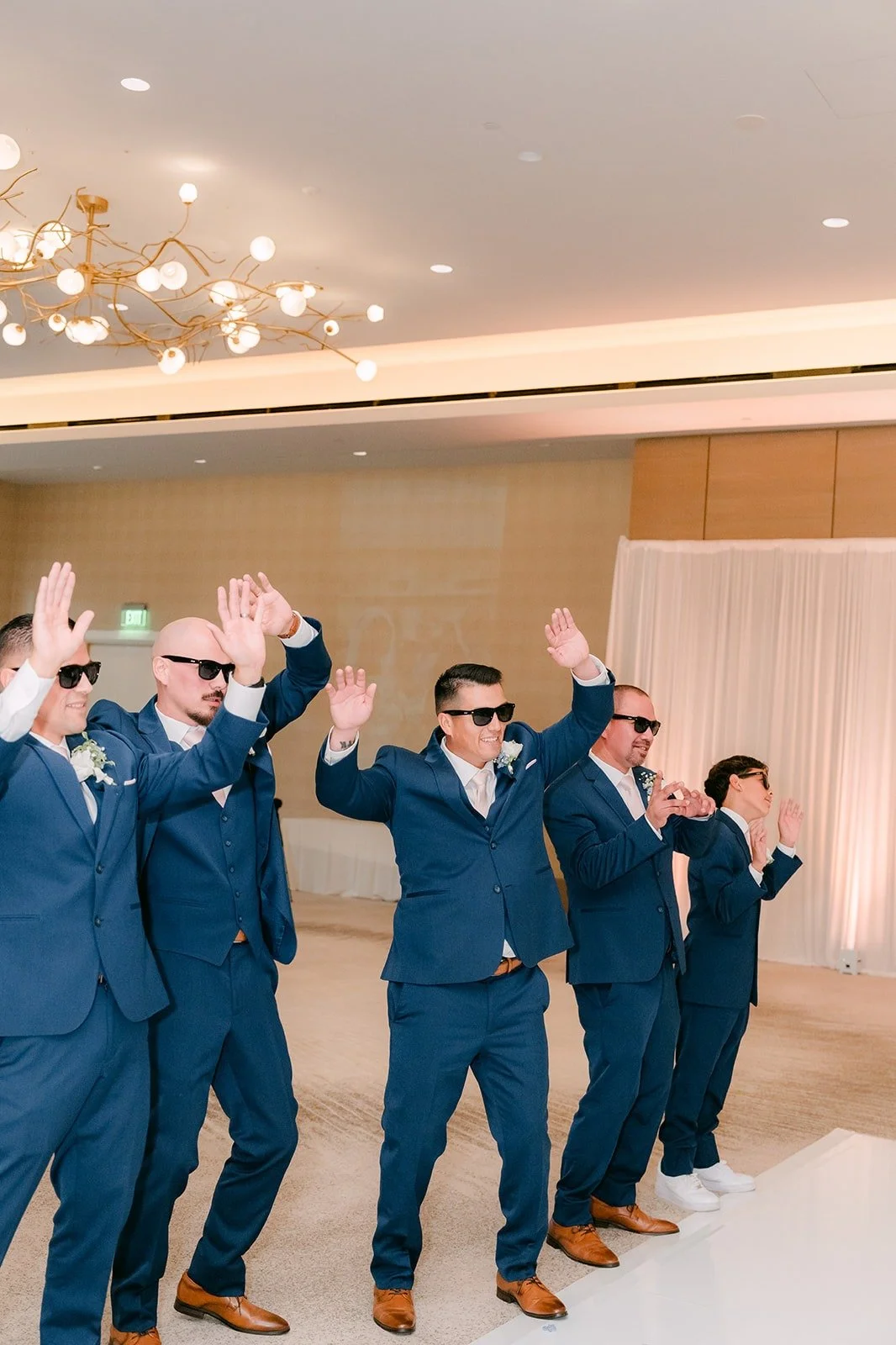 The groomsmen in sunglasses dance their way into the ballroom