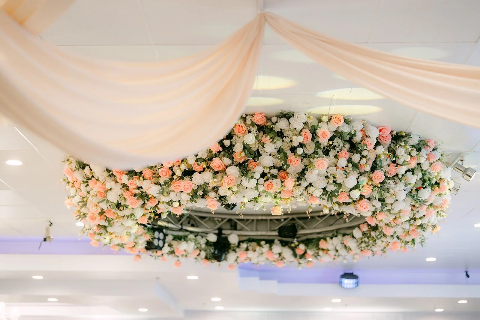 Floral installation of pink roses and hydrangeas over the reception stage