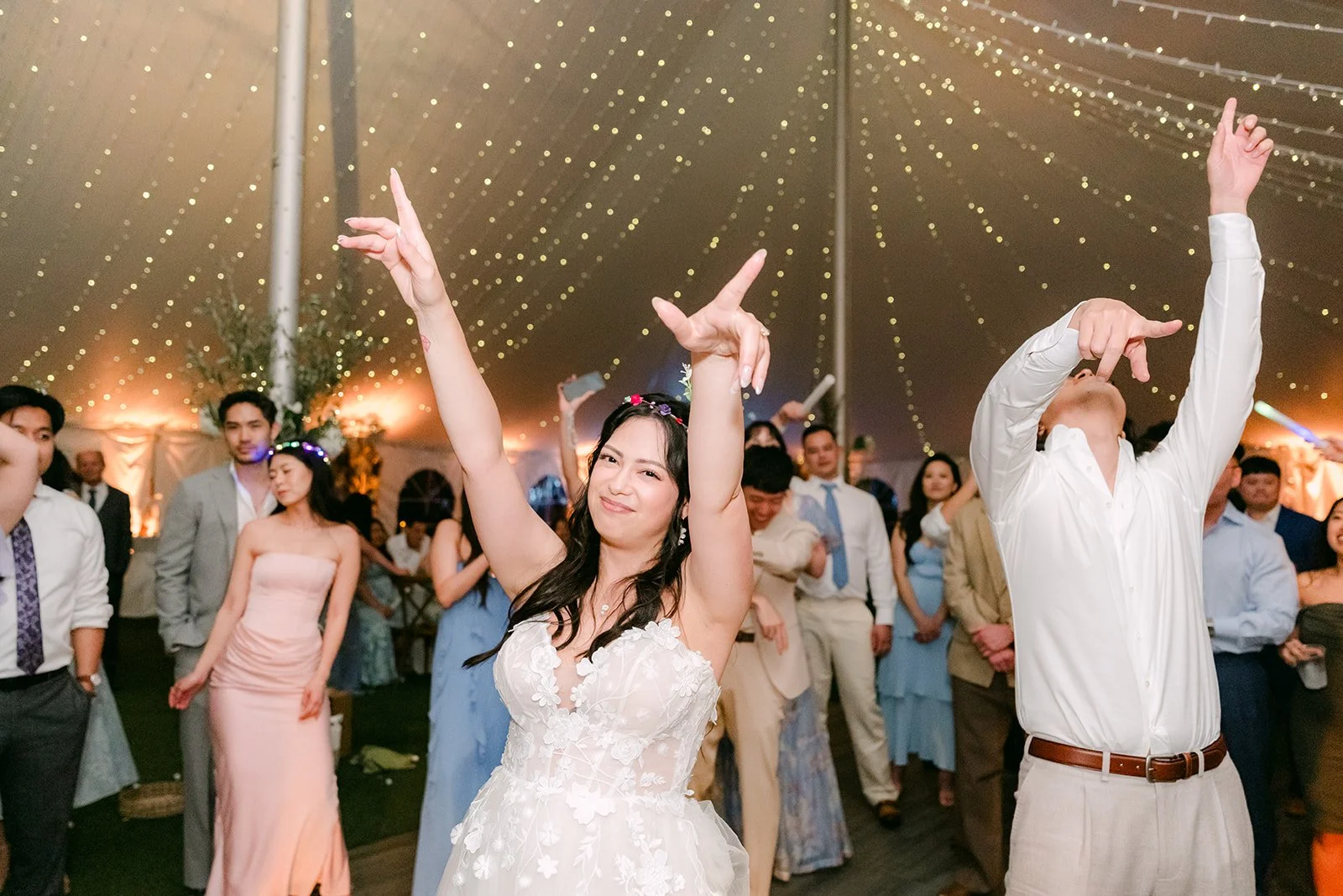 Bride and groom dancing with their arms in the air