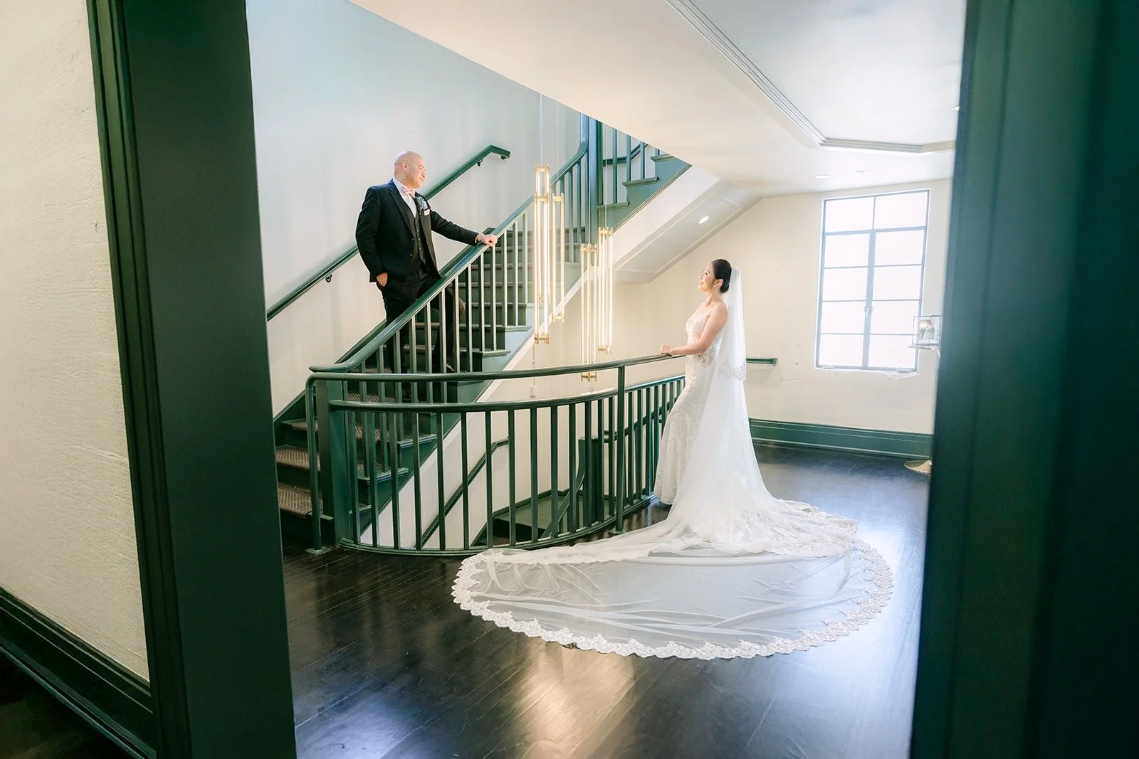 Elisa and Brandon on the green staircase at The Headquarters