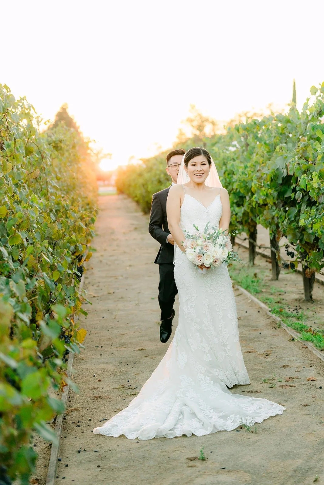 Xuemin in her lace gown between the vines at sunset