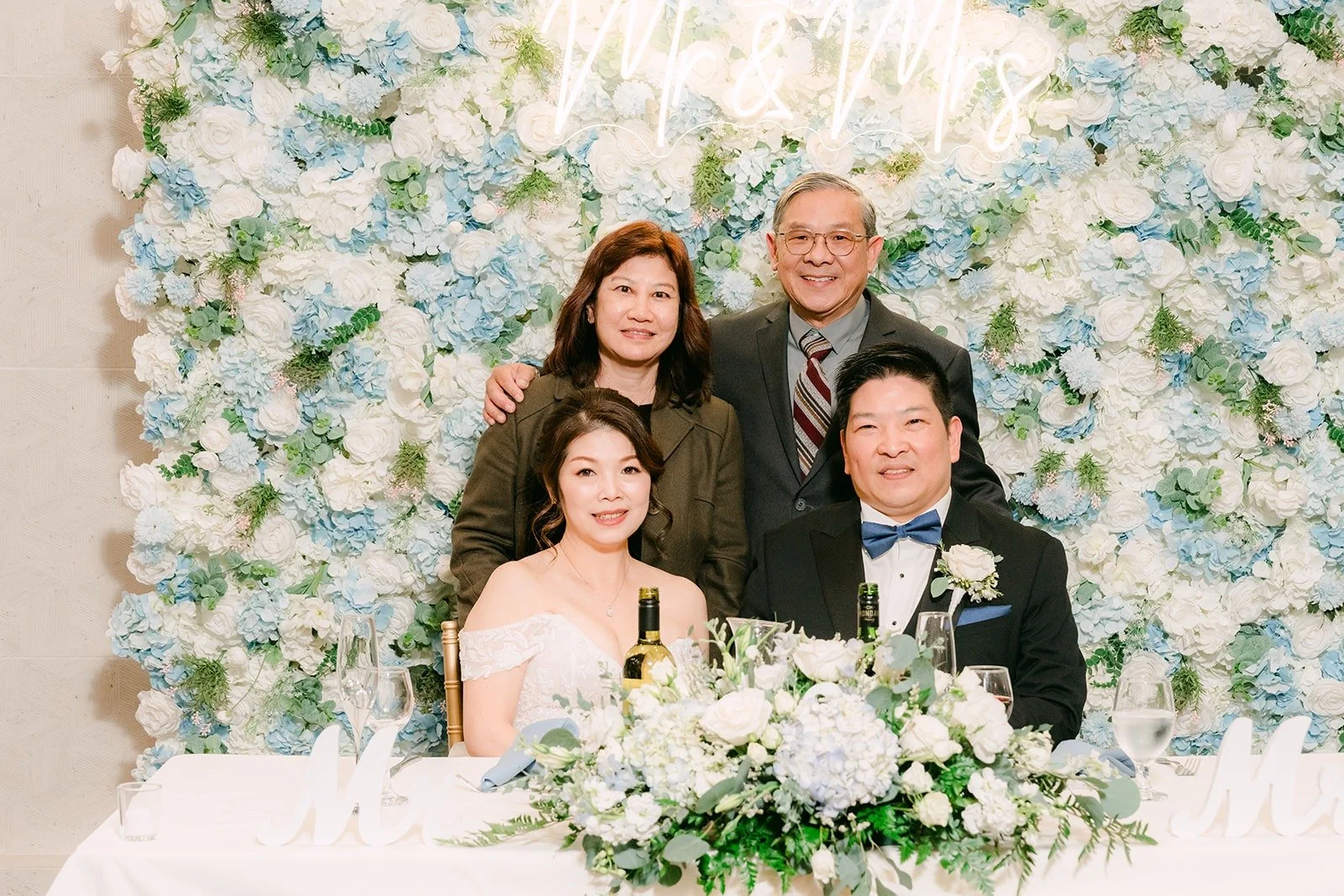 Sochi and Jay pose with two family members at the sweetheart table