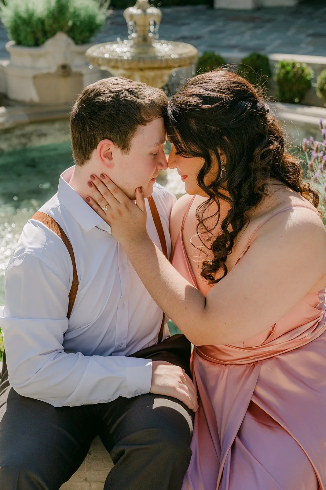 Saira and Matthew sharing a close moment on the fountain ledge.