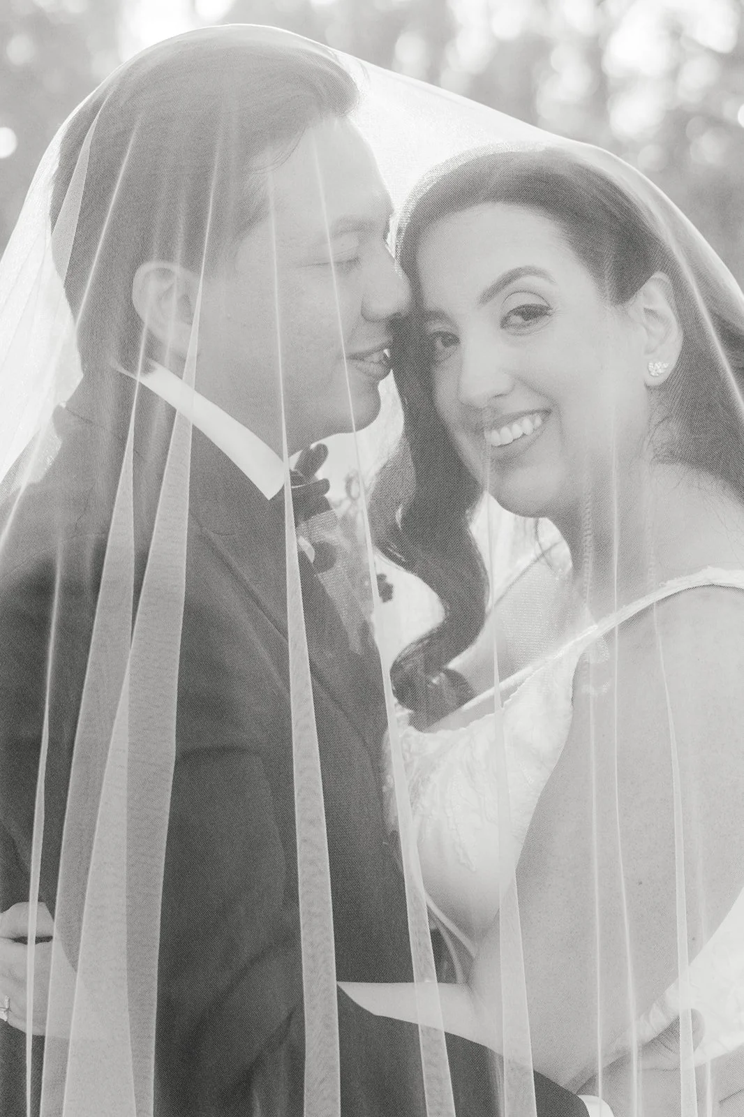 Black and white portrait of the couple under the veil