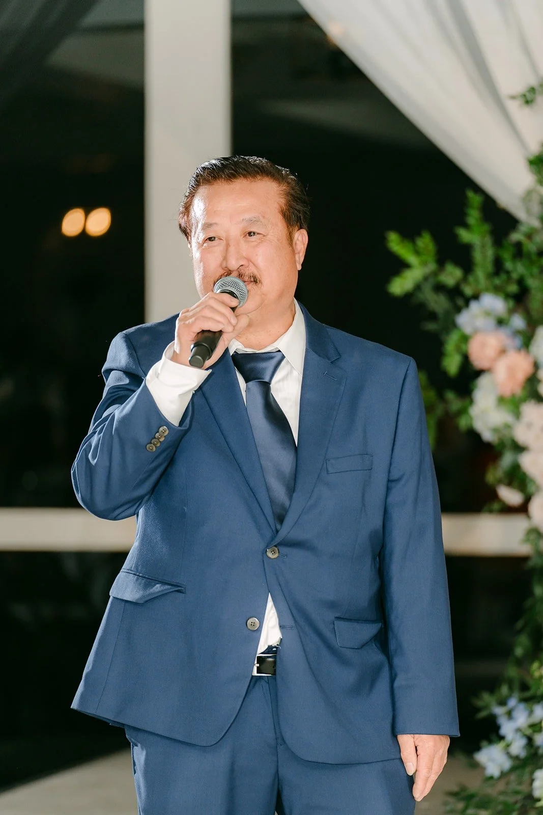 A family member giving the welcome toast in the ballroom