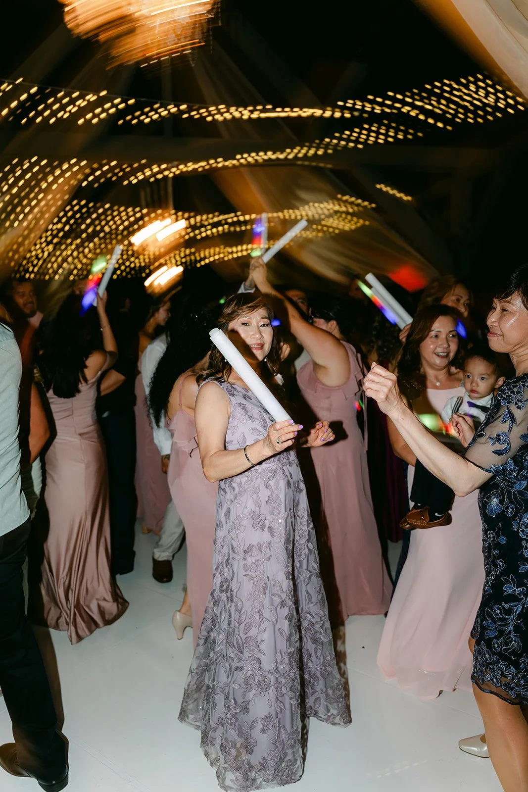 Bridesmaids dancing under the string lights.