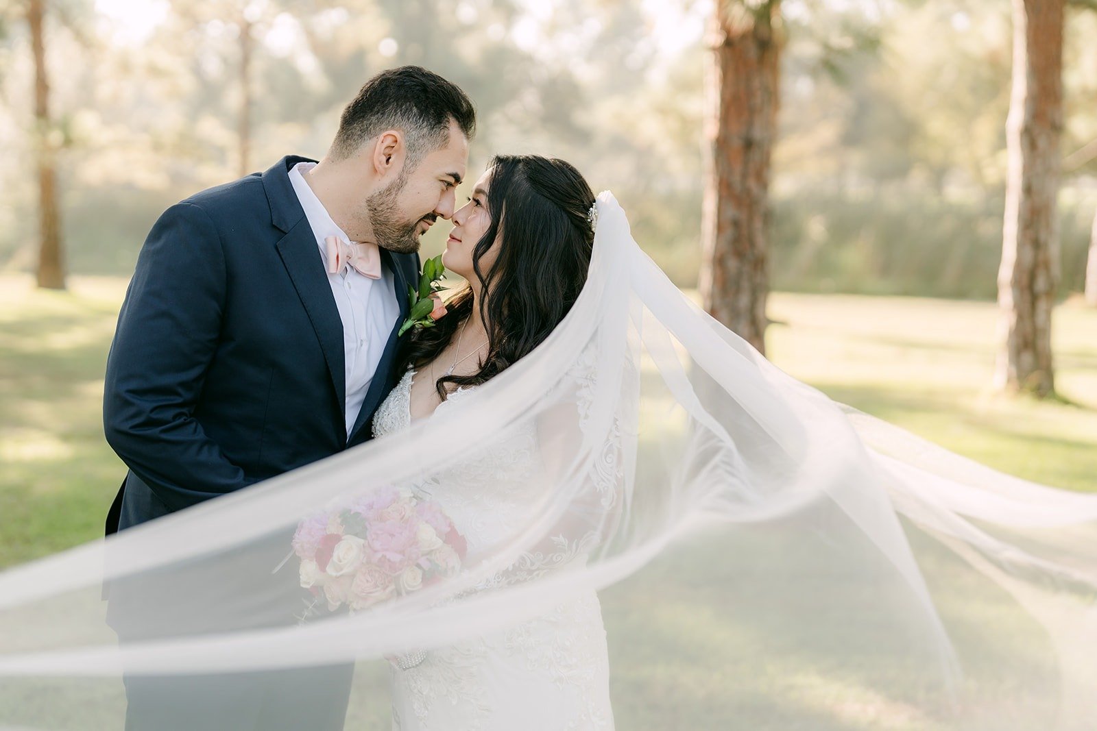 Amy and James sharing a kiss with her veil streaming in the wind
