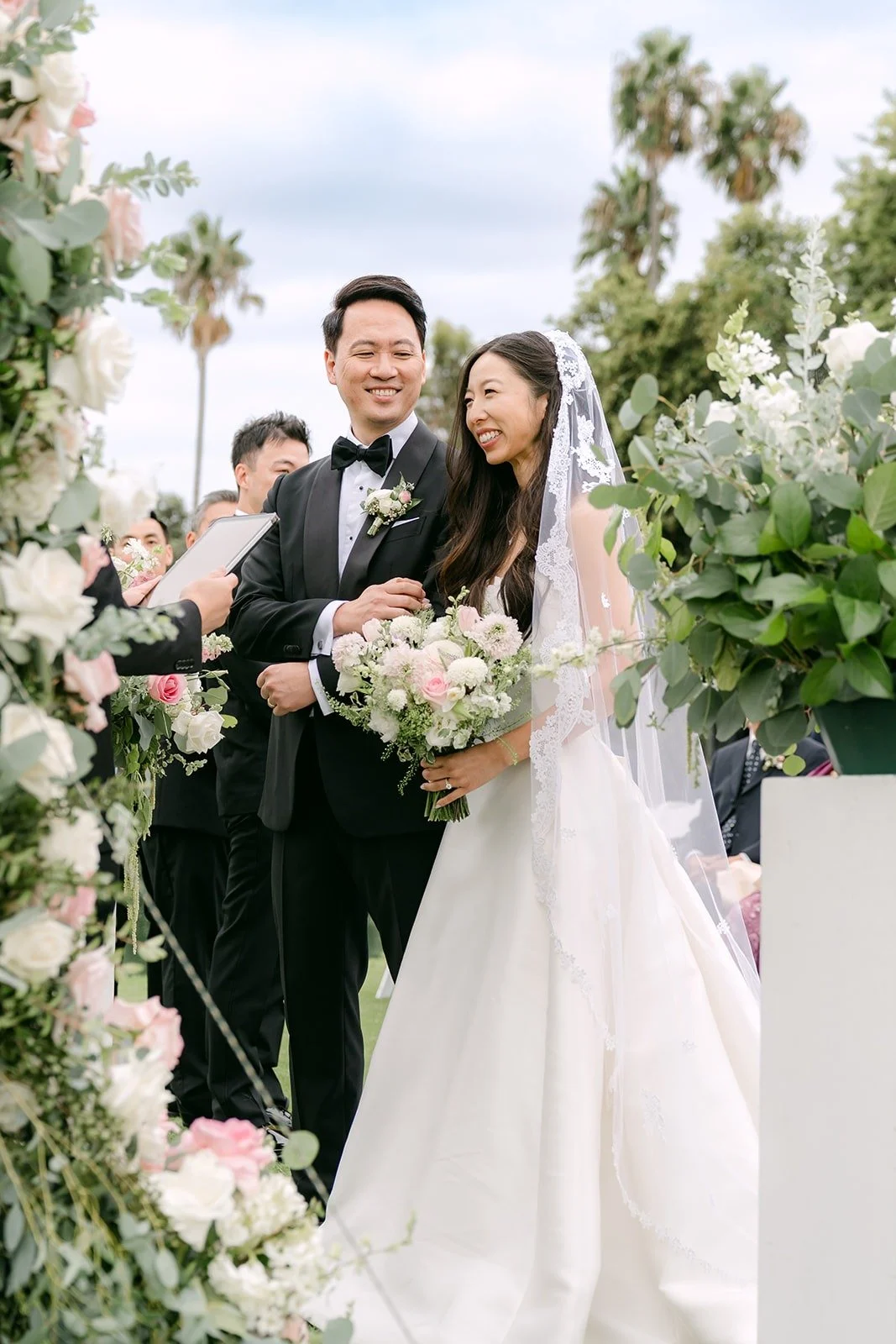 Kristine and William smiling at the arch as husband and wife